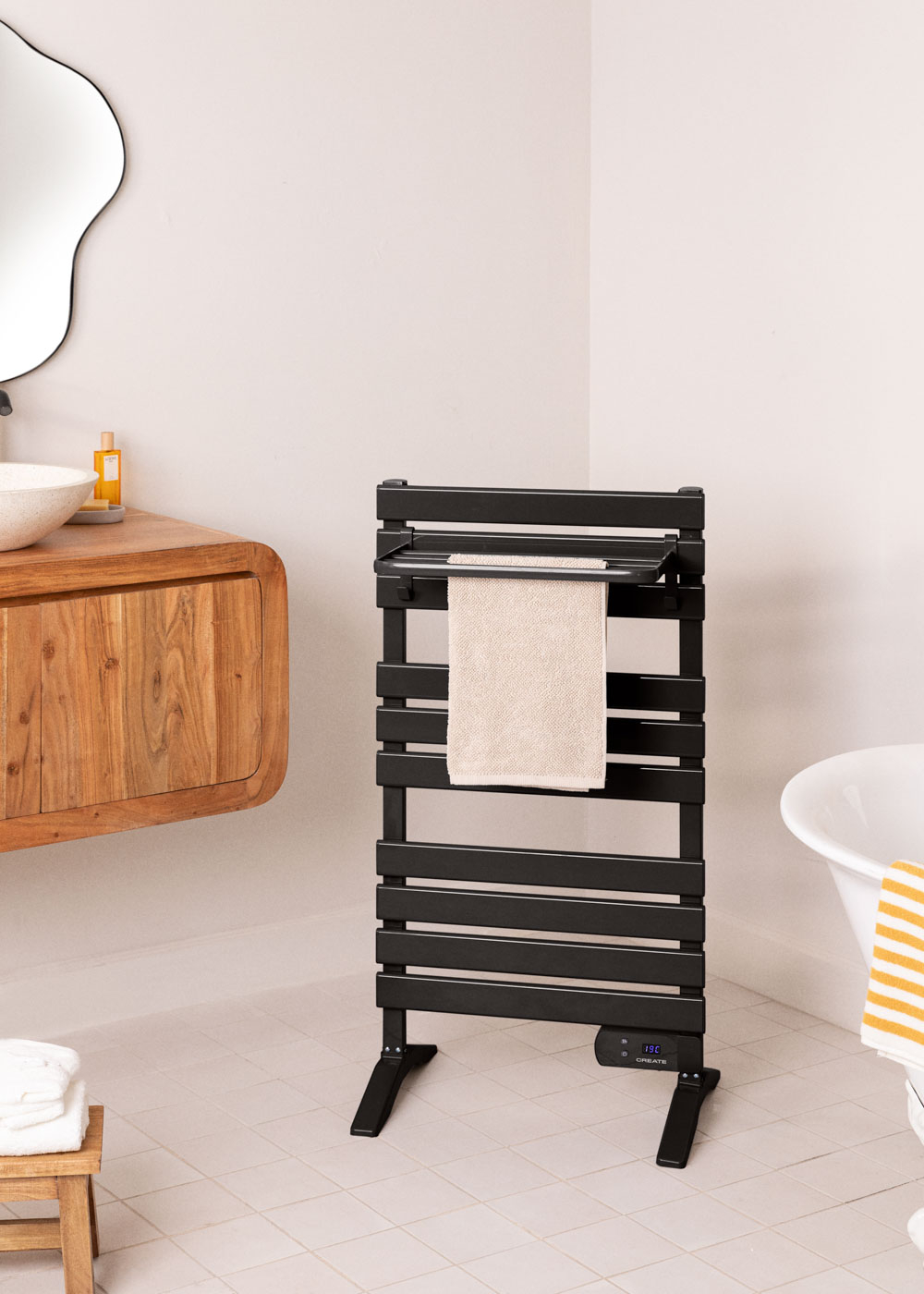 Un toallero negro con una toalla en un baño, una bañera a la derecha.