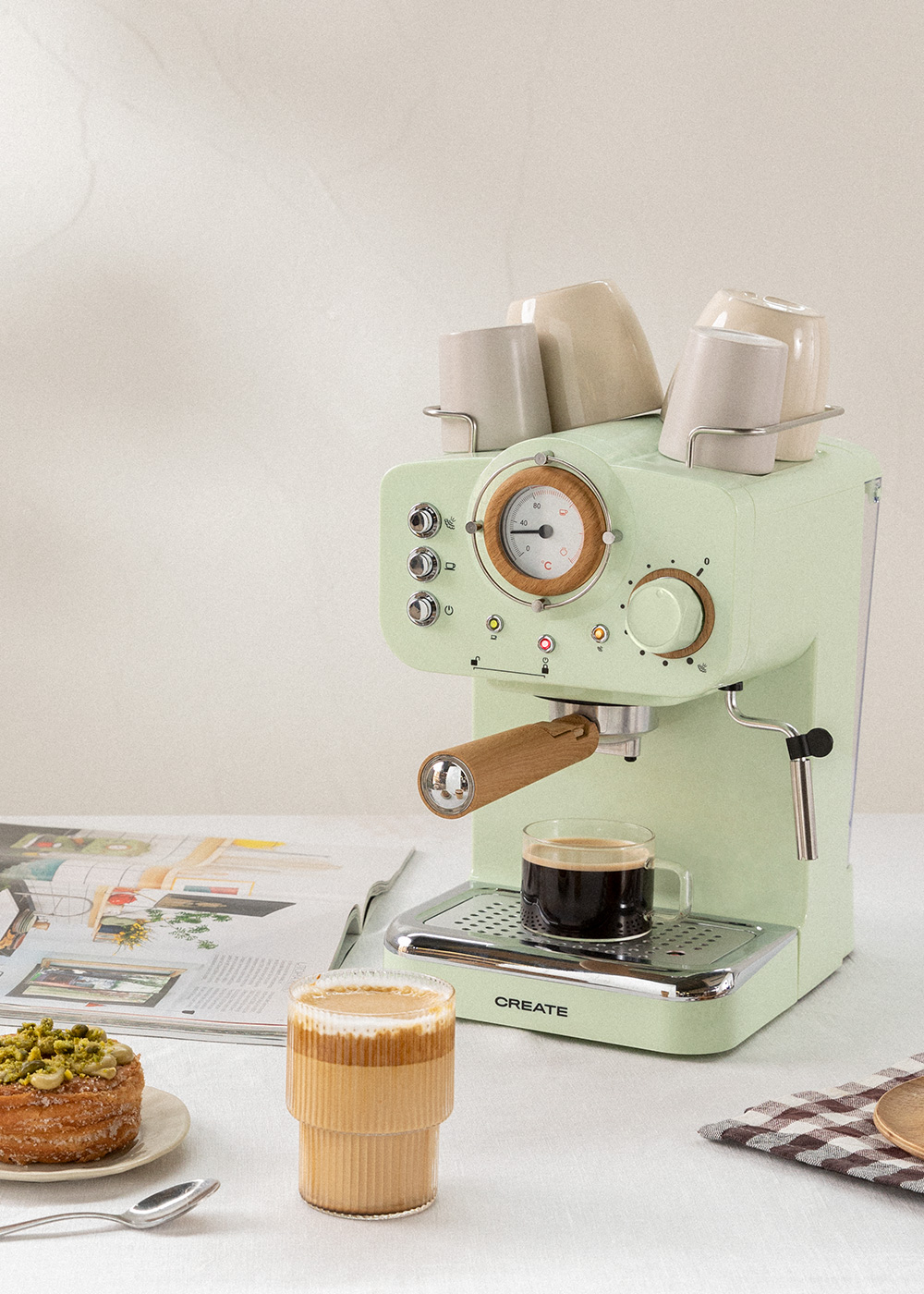 Máquina de espresso retro verde con una taza de café. Máquina en una mesa blanca. Etiqueta CREATE.
