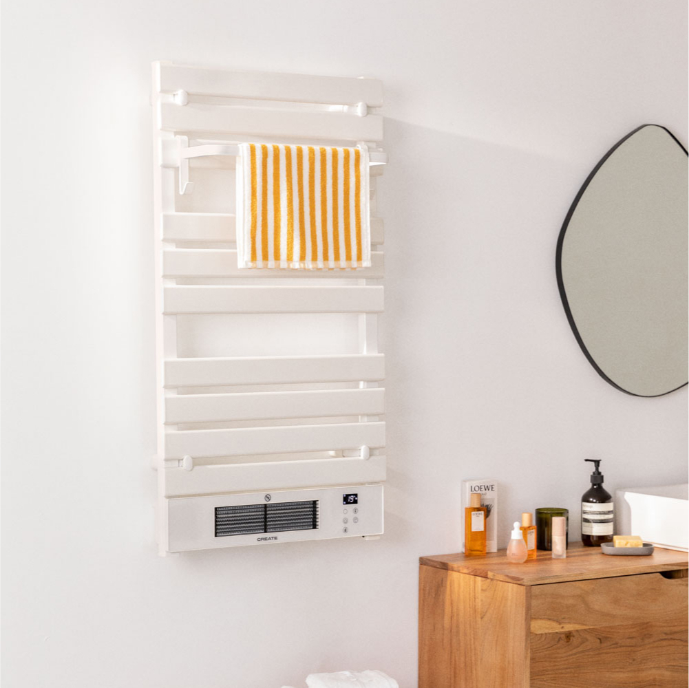 Calentador de toallas blanco en la pared con toalla. Espejo y artículos de baño. Ambiente blanco y limpio.