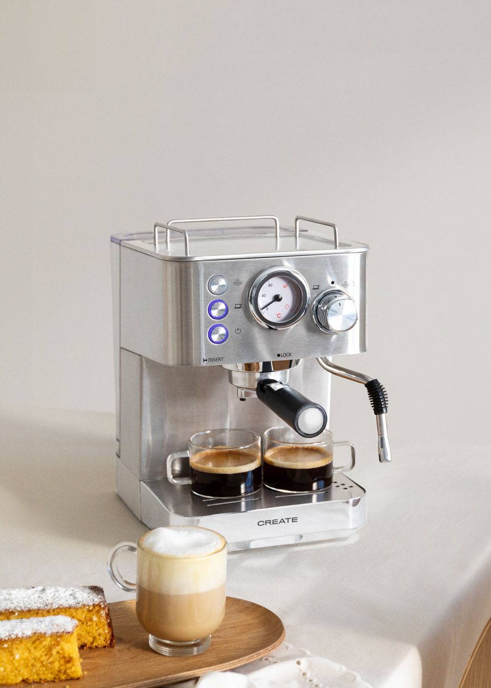 Máquina de espresso con dos tazas de café y un latte.