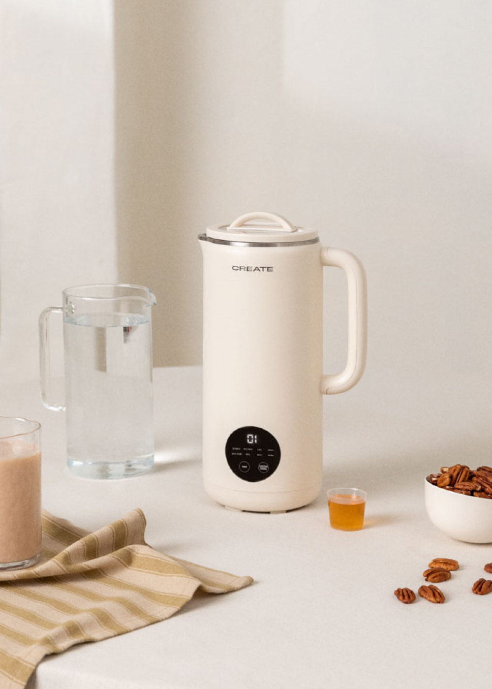 Electrodoméstico blanco con pantalla. Un vaso de agua, nueces y miel están al lado.