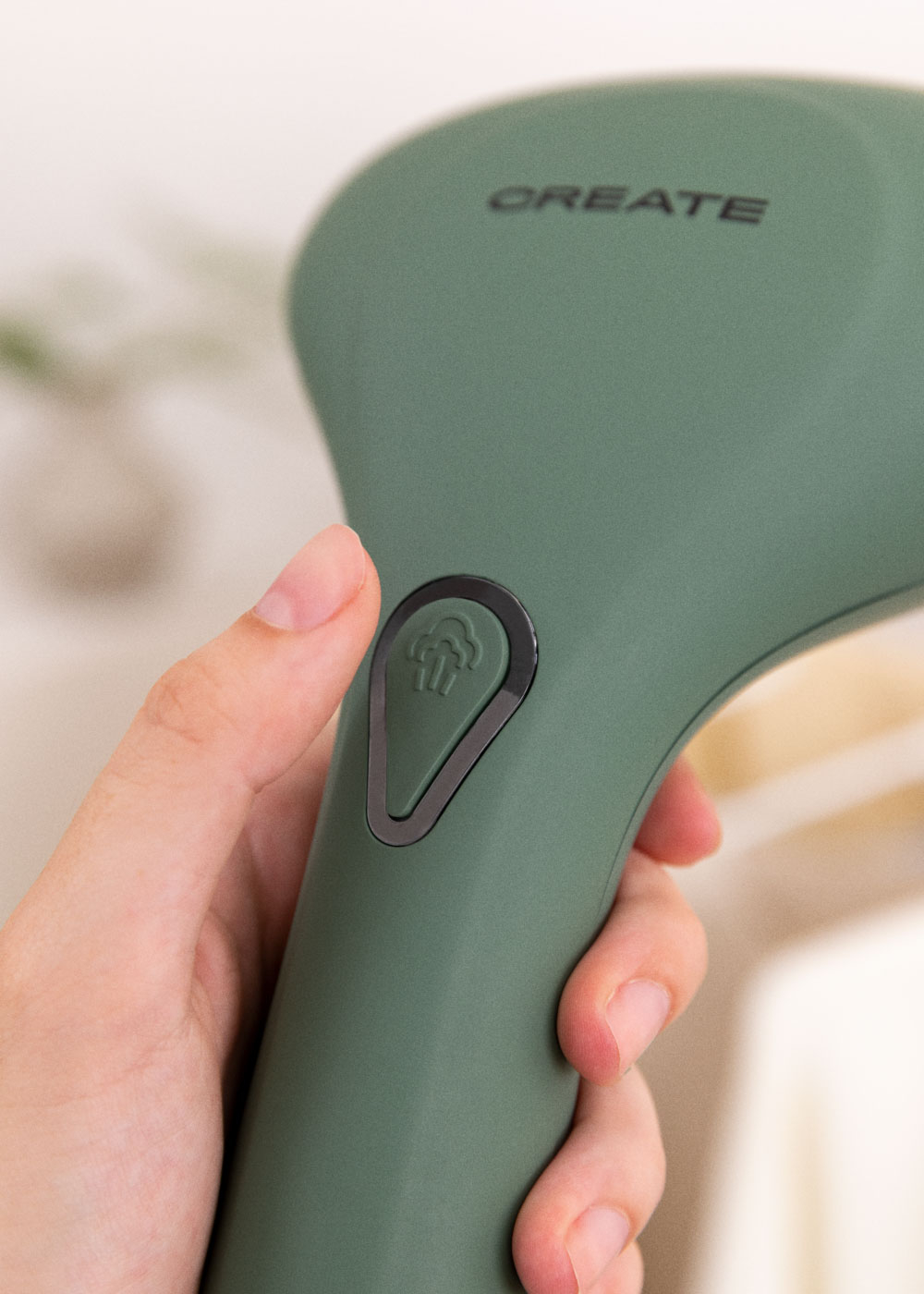 La mano de una persona presiona un botón en un vaporizador verde. Fondo blanco.