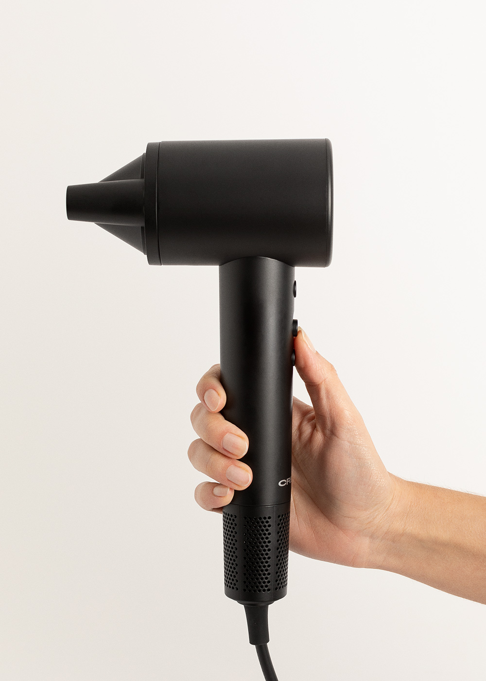 Secador de pelo negro en la mano. Fondo blanco. Diseño negro.