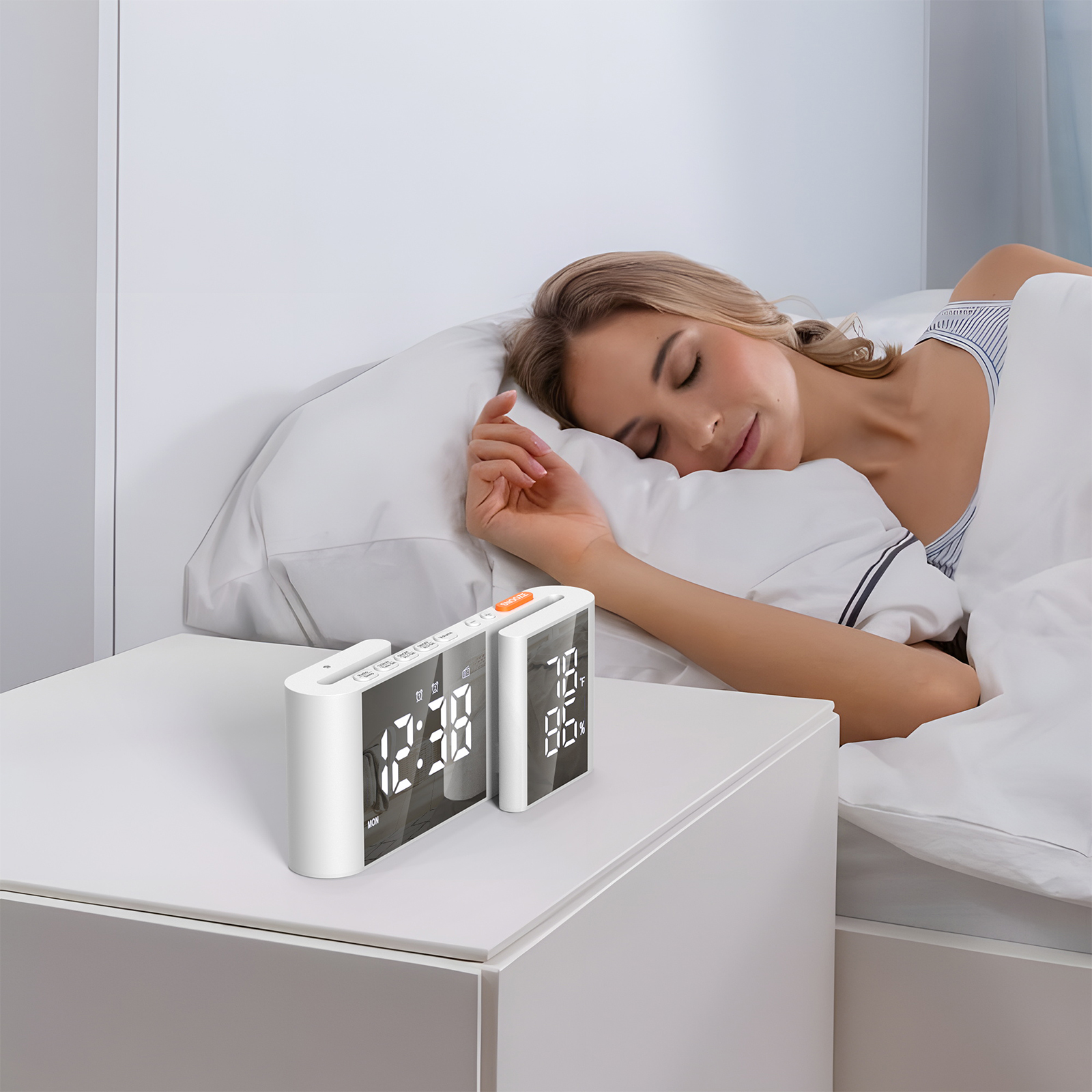 Frau schläft im Bett mit zwei weißen Digitaluhren auf einem weißen Nachttisch. Die Uhren zeigen die Zeit.