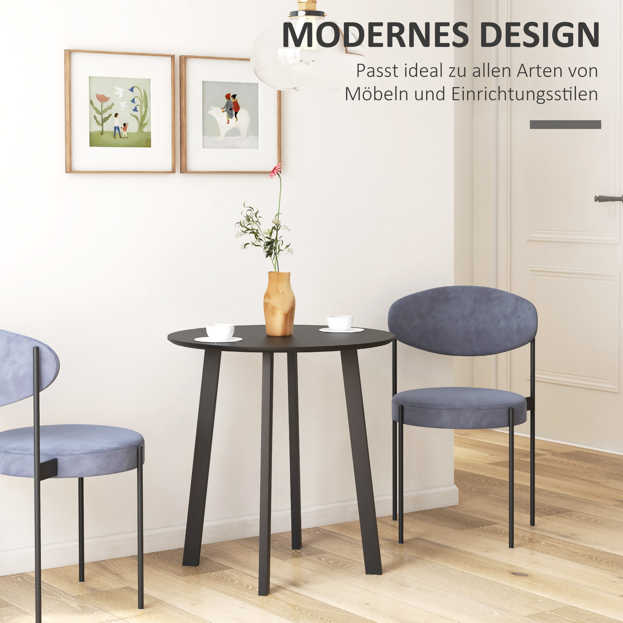 Ein modernes Ess-Set mit einem runden schwarzen Tisch und zwei blauen Stühlen, mit Kunstdrucken an der Wand.