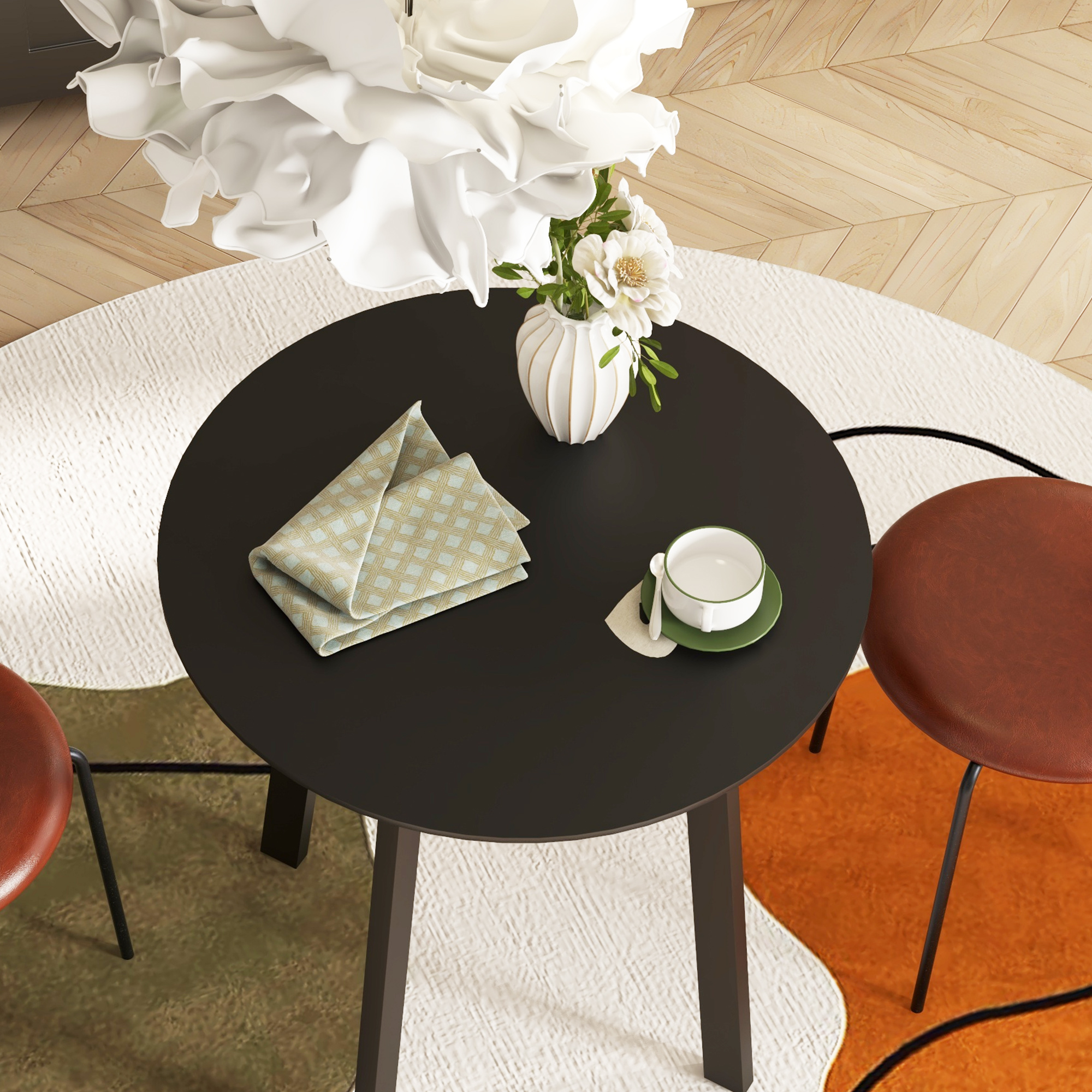 Ein schwarzer runder Tisch mit einer weißen Vase, Blumen, einer Serviette und einer Tasse.