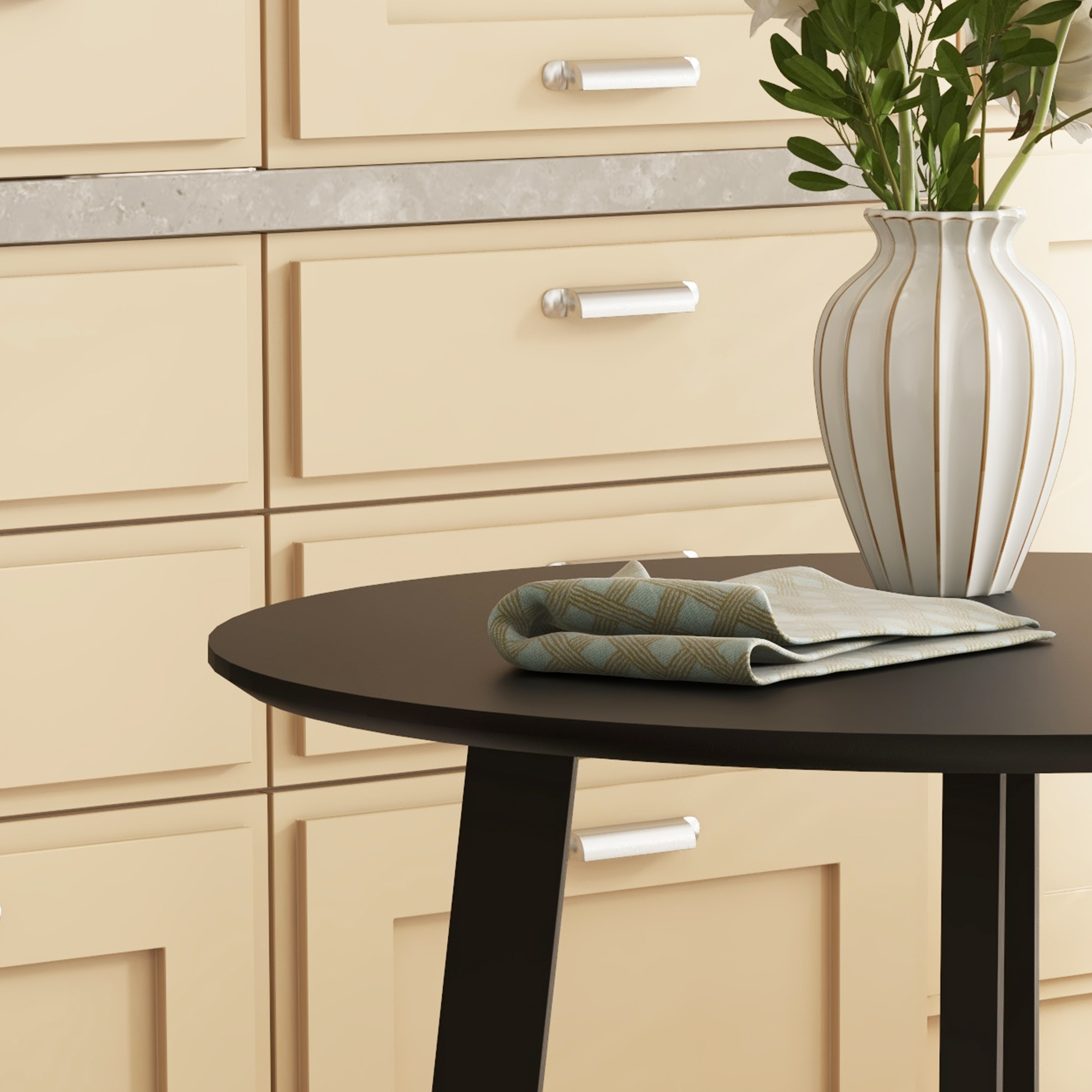 Ein runder, schwarzer Tisch mit einer weißen Vase, Blumen und einem gefalteten Tuch. Beige Schränke im Hintergrund.