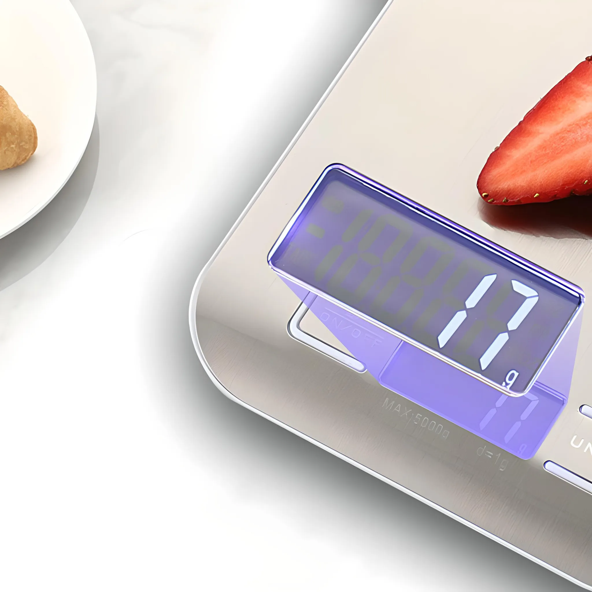 Eine Digitalwaage mit einer Erdbeere und einem Gebäck. Die Waage ist lila und zeigt das Gewicht an.