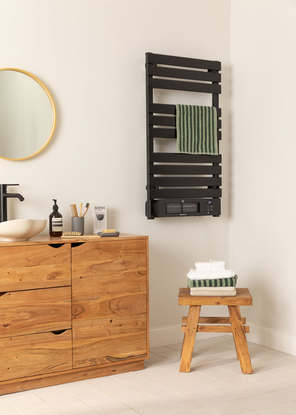 Escena de baño con un toallero negro y muebles de madera.