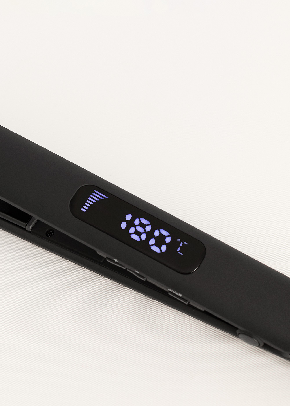 Plancha de pelo negra con pantalla digital que muestra 180 grados Celsius.