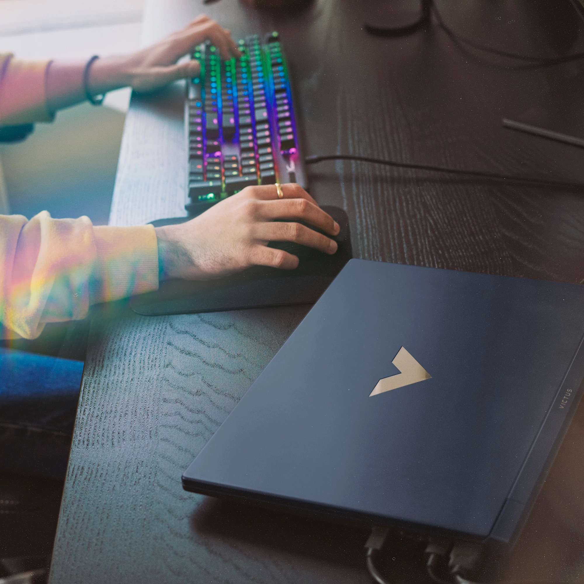 Osoba korzystająca z laptopa z klawiaturą i myszą, widoczne logo Victus.