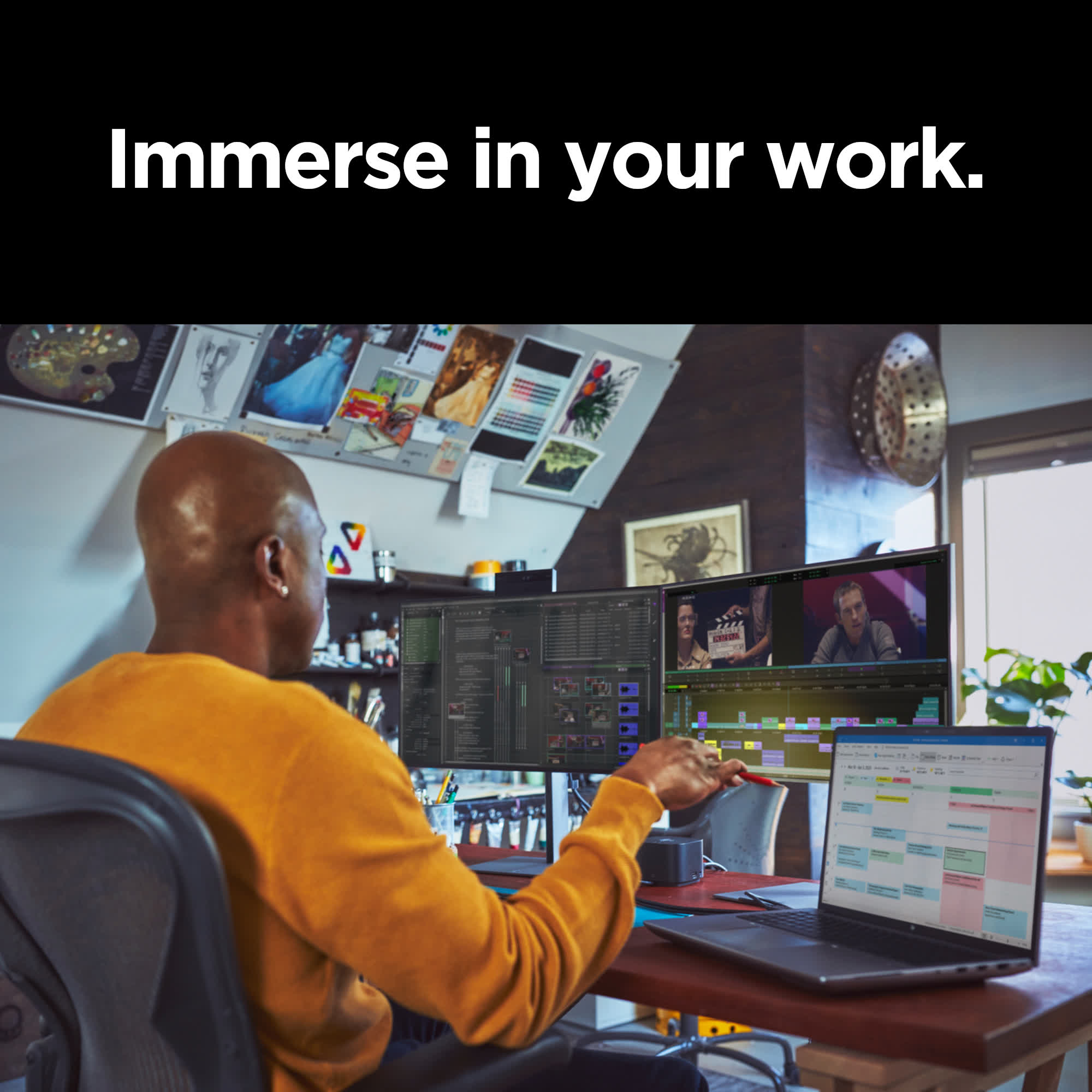 Mężczyzna pracujący na dwóch ekranach komputera, edytujący wideo, z laptopem na biurku.