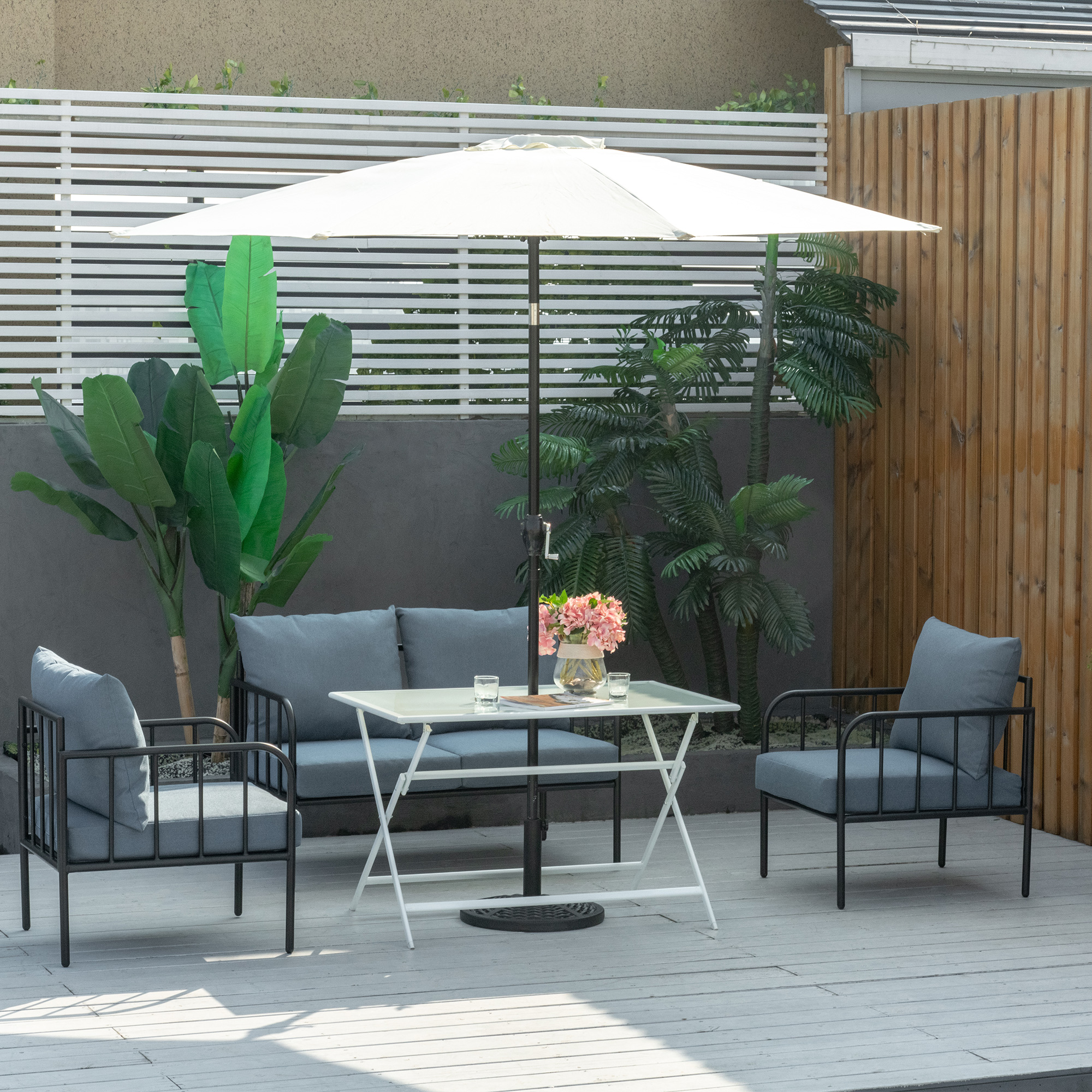 Terrassenmöbel, Tisch und Stühle, mit Sonnenschirm. Holzzaun im Hintergrund.