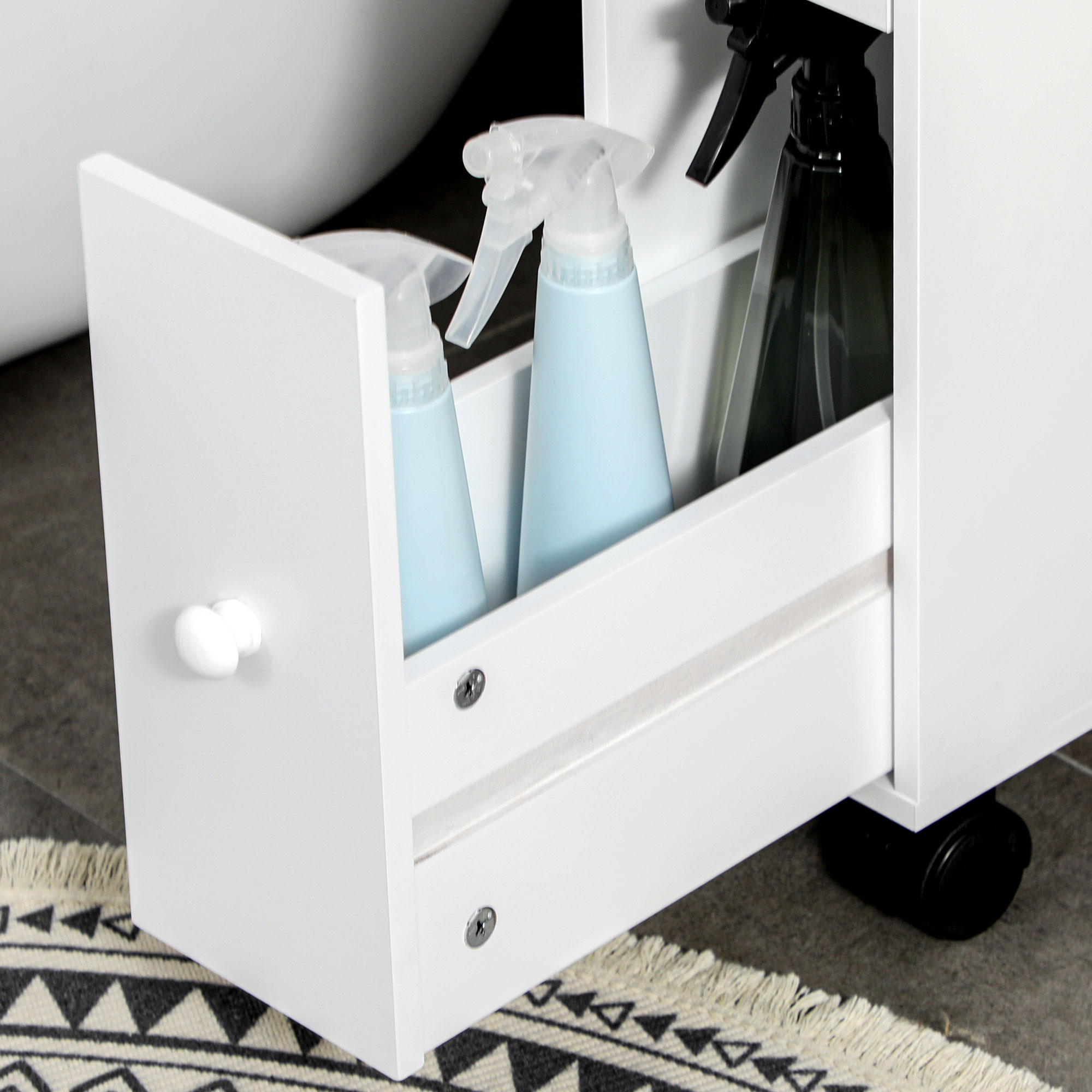 Weißer Schrank mit offener Schublade, Reinigungsmittel. Schwarz-weißer Teppich.