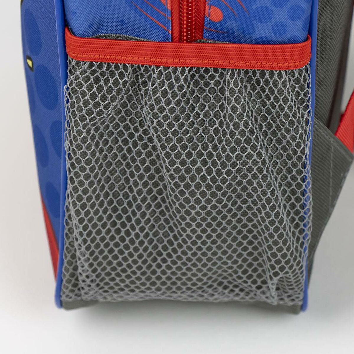 Ein blauer Rucksack mit einer seitlichen Netztasche und einem roten Reißverschluss. Nahaufnahme.
