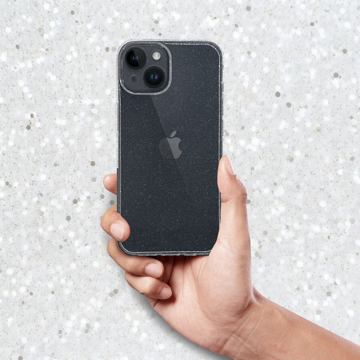 Hand hält ein schwarzes iPhone mit Dreifach-Kamera auf glitzerndem Hintergrund.