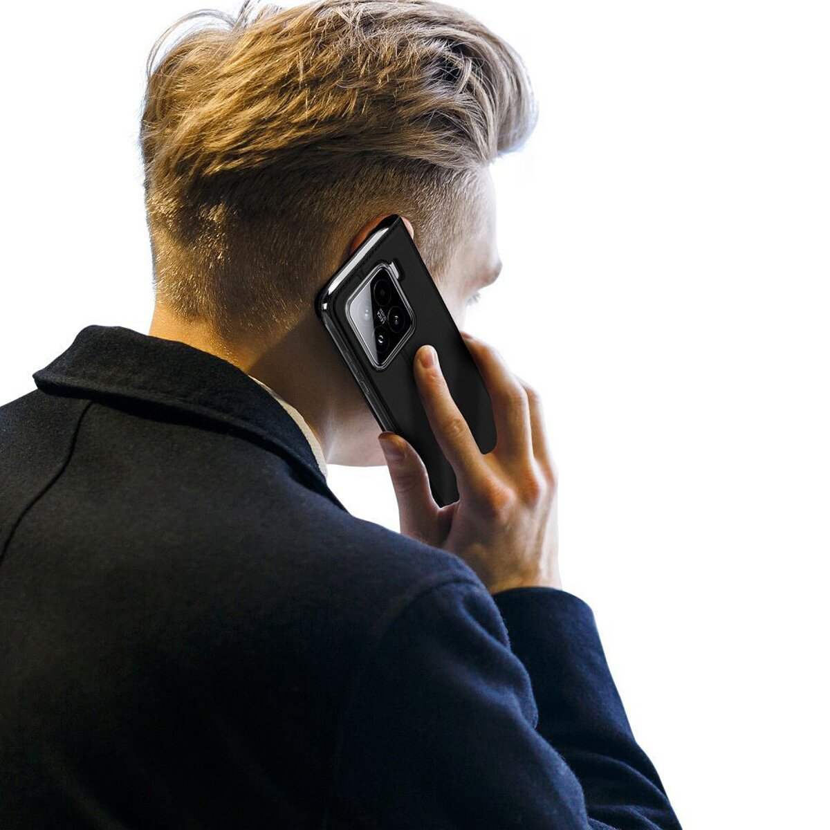 Ein Mann hält ein schwarzes Smartphone an sein Ohr. Er trägt einen dunklen Mantel.