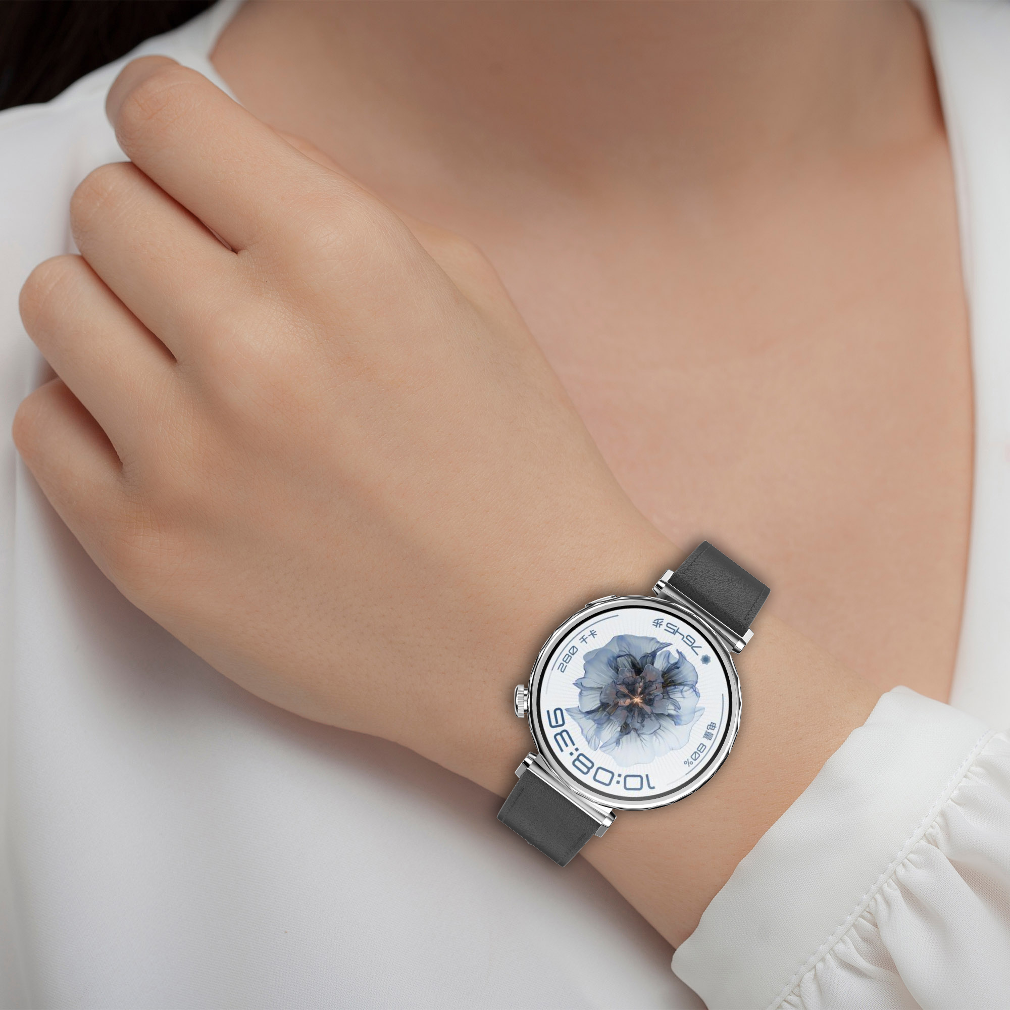 Il polso di una persona con un moderno orologio rotondo con un design floreale sul quadrante.