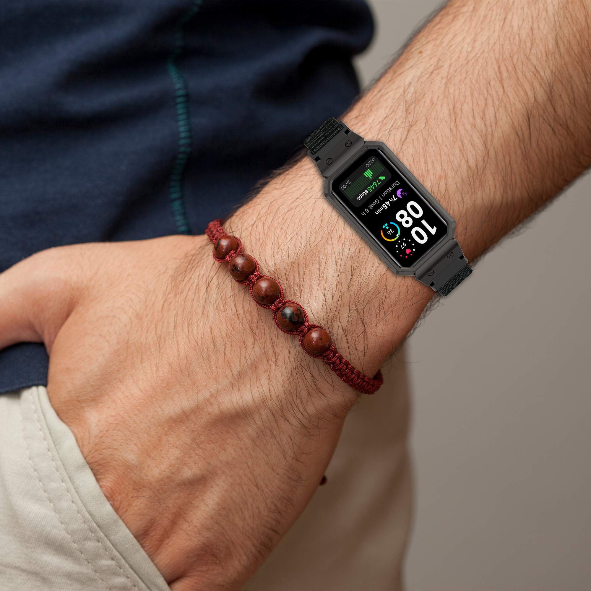 Un fitness tracker su un polso. È visibile anche un braccialetto di perline.