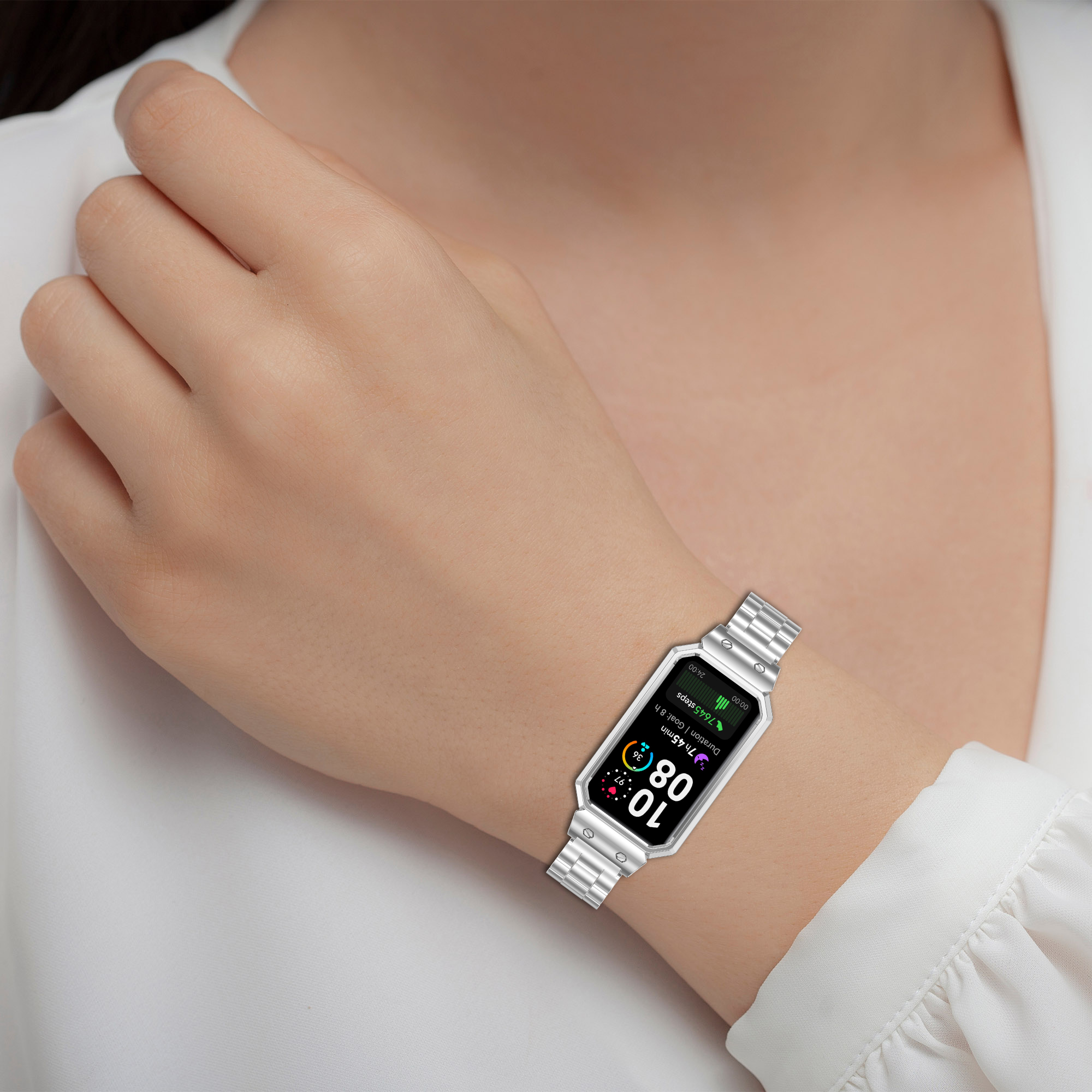 Das Handgelenk einer Frau mit einer silbernen Uhr. Die Uhr zeigt Zeit und Schritte auf einem Bildschirm an.