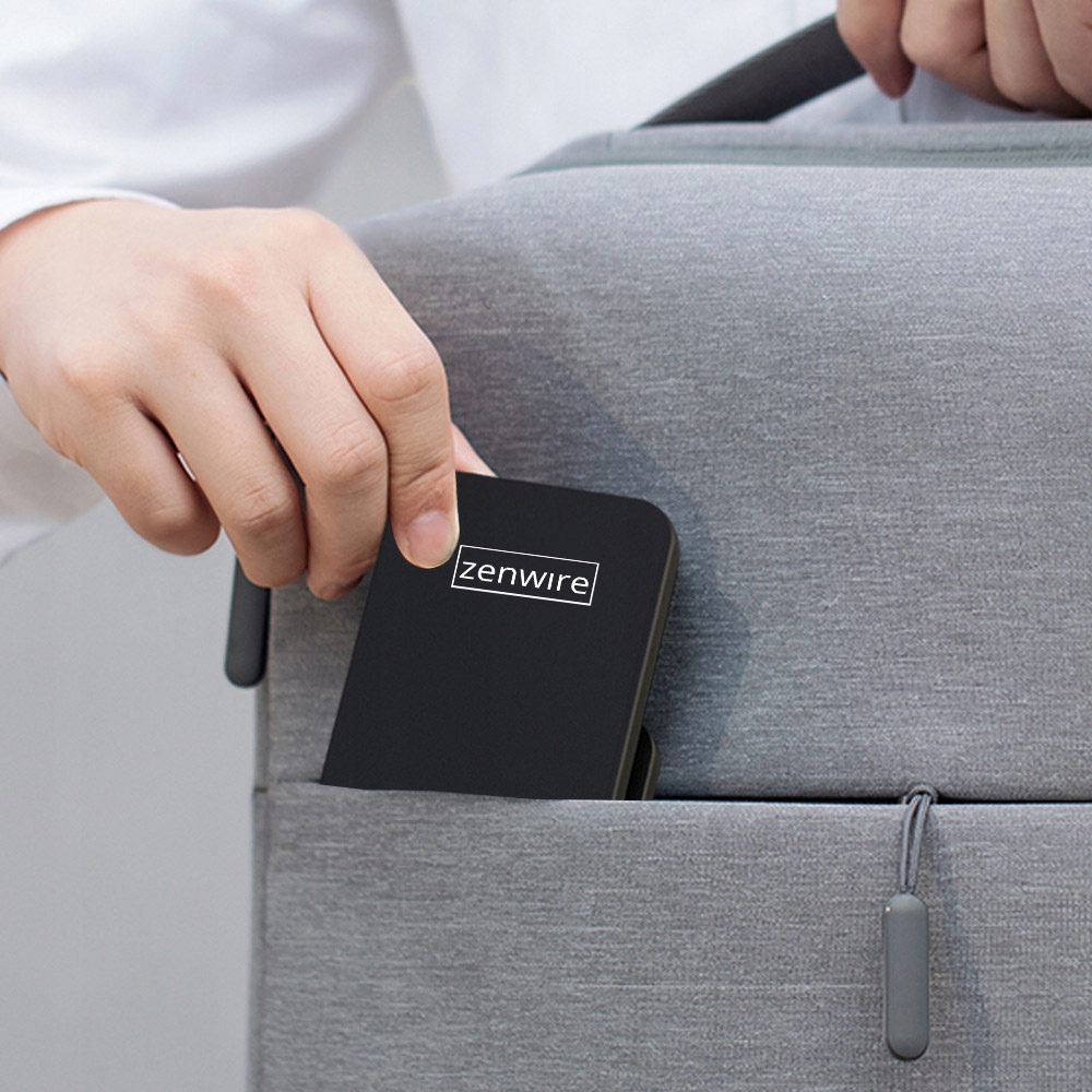 Osoba wkładająca czarne urządzenie Zenwire do szarej torby. Urządzenie ma logo Zenwire.