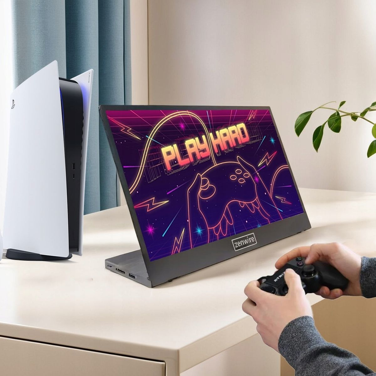 Osoba grająca w grę wideo na monitorze podłączonym do konsoli PS5. Na ekranie napis 'PLAY HARD'.