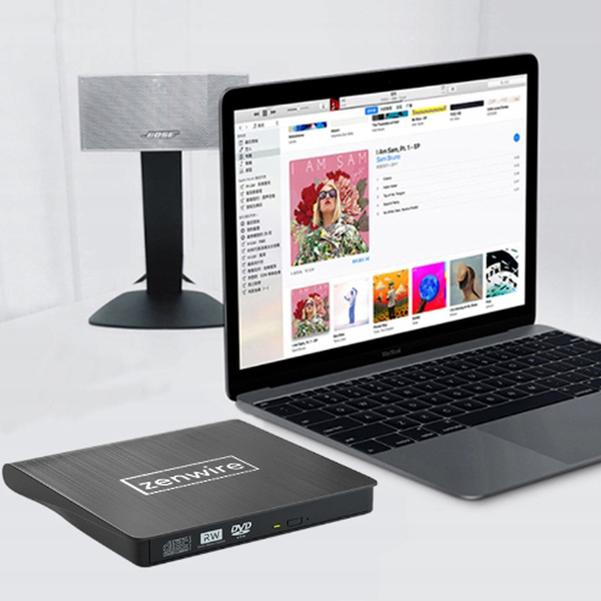 Czarny napęd zewnętrzny Zenwire obok laptopa i głośnika. Laptop wyświetla interfejs muzyczny.