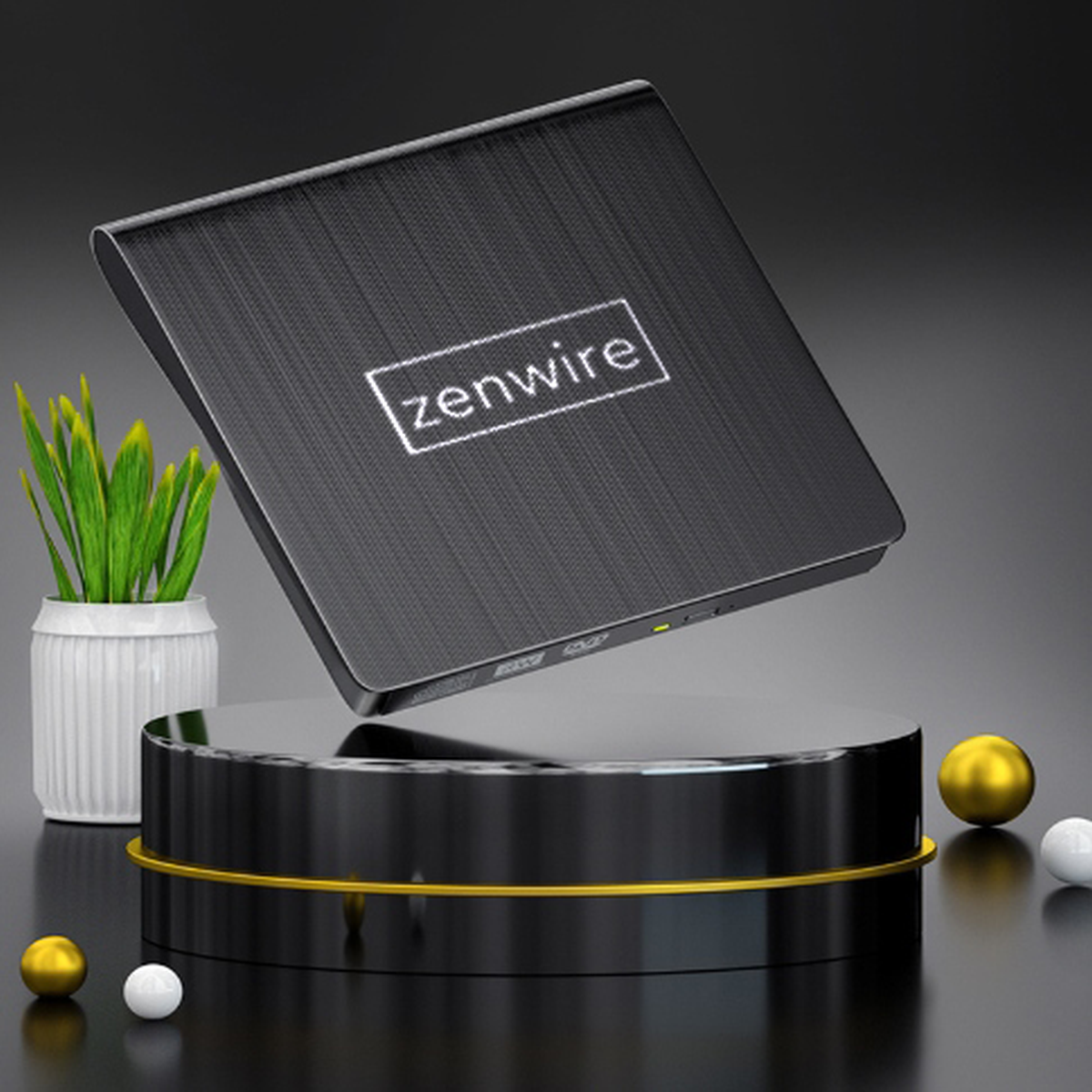 Czarny dysk zewnętrzny Zenwire na czarnej platformie, z małą rośliną, złotymi i białymi kulami. Widoczne logo.