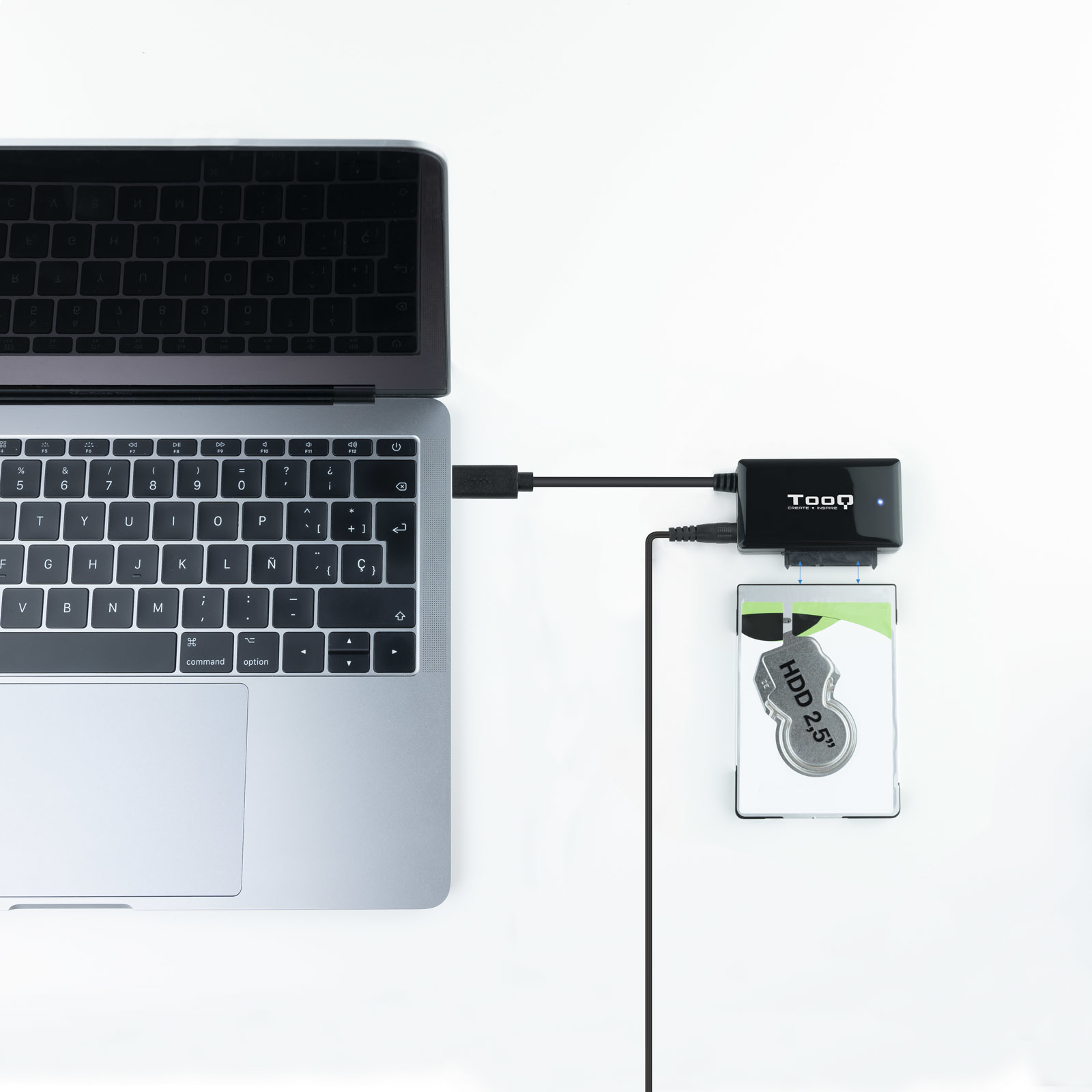 Laptop collegato a docking station per hard disk con hard disk inserito. Sfondo bianco.
