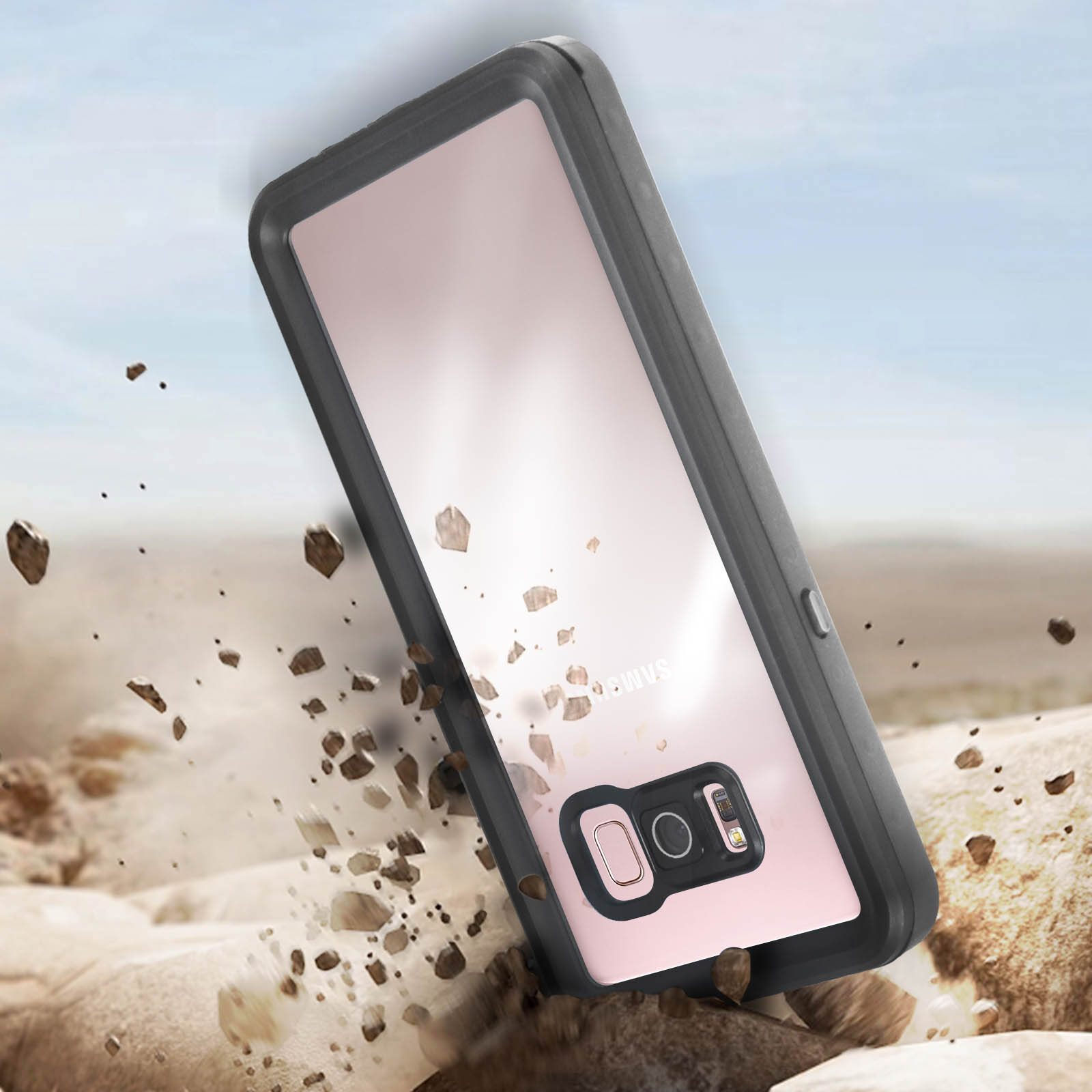 Un teléfono en una funda protectora yace en el suelo. Suciedad y rocas dispersas alrededor del teléfono.