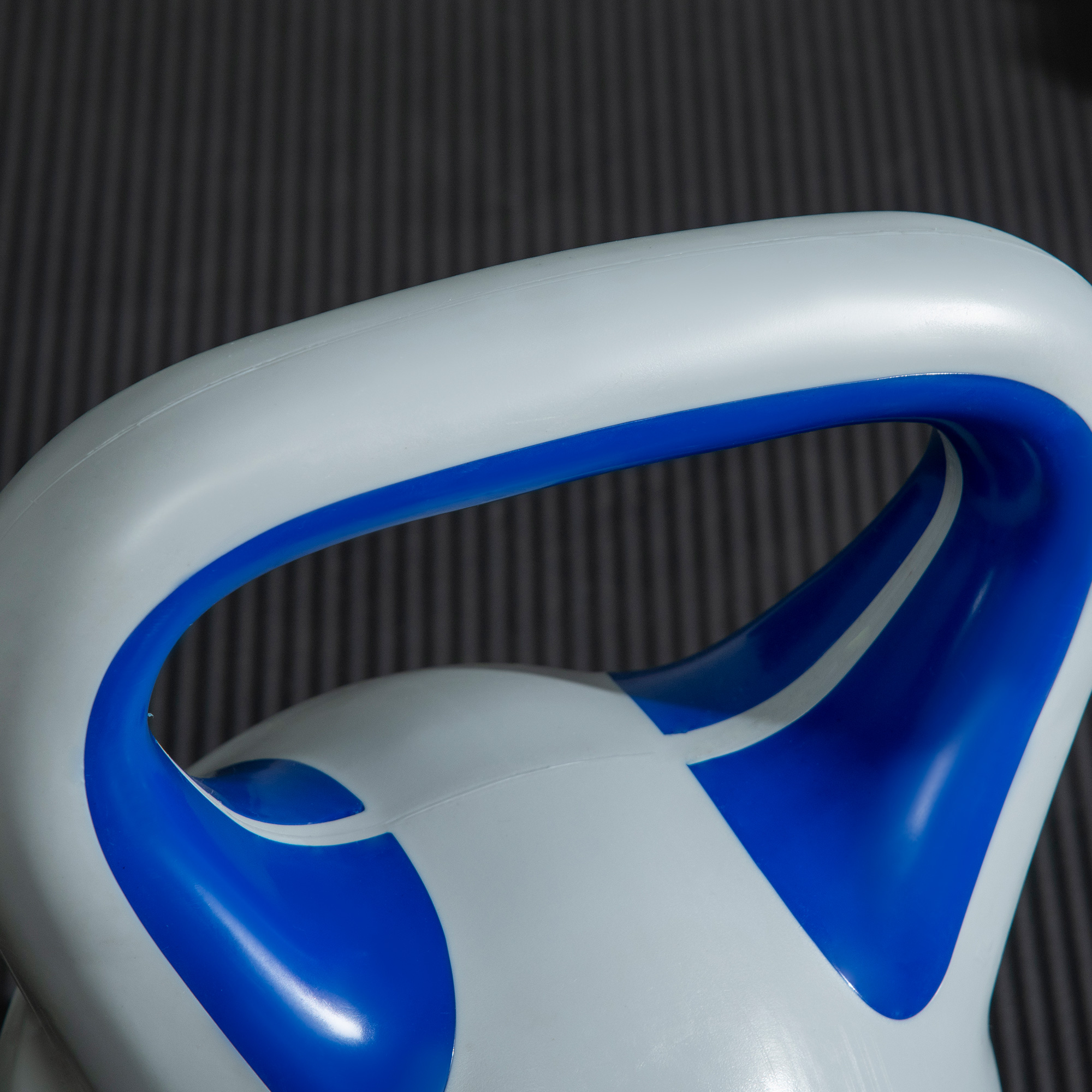 Weiß-blaue Kettlebell, Nahaufnahme, mit blauem Griff und weißem Körper, auf grauem Hintergrund.