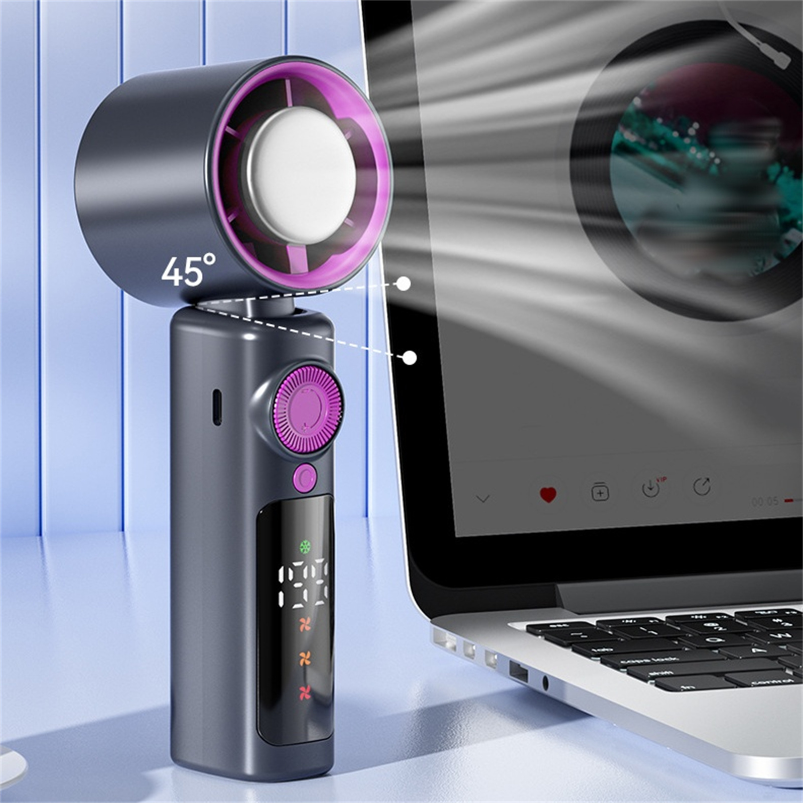 Tragbarer Ventilator, schwarz und rosa, angewinkelt, mit Laptop-Bildschirm im Hintergrund.