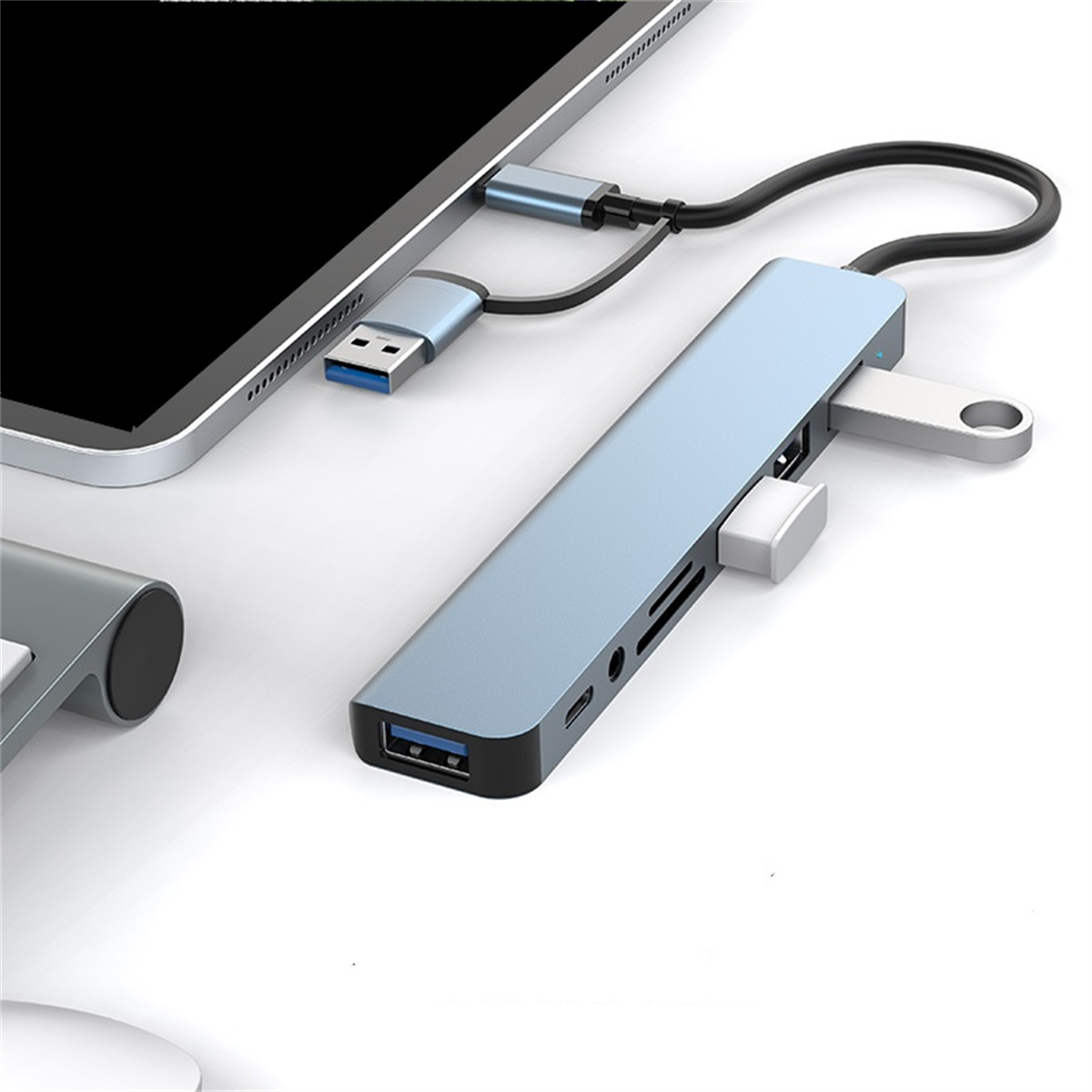 Blauer USB-Hub, der mit einem Tablet verbunden ist. Silber- und Blautöne. Weißer Hintergrund.