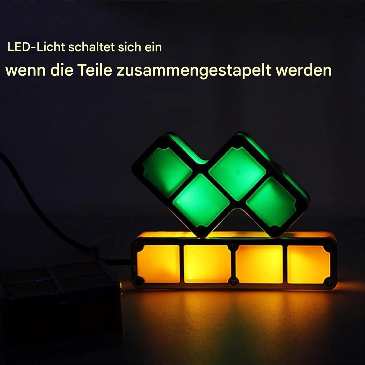 Zwei Tetris-ähnliche Blöcke, einer grün, einer gelb, leuchten in dunkler Umgebung.