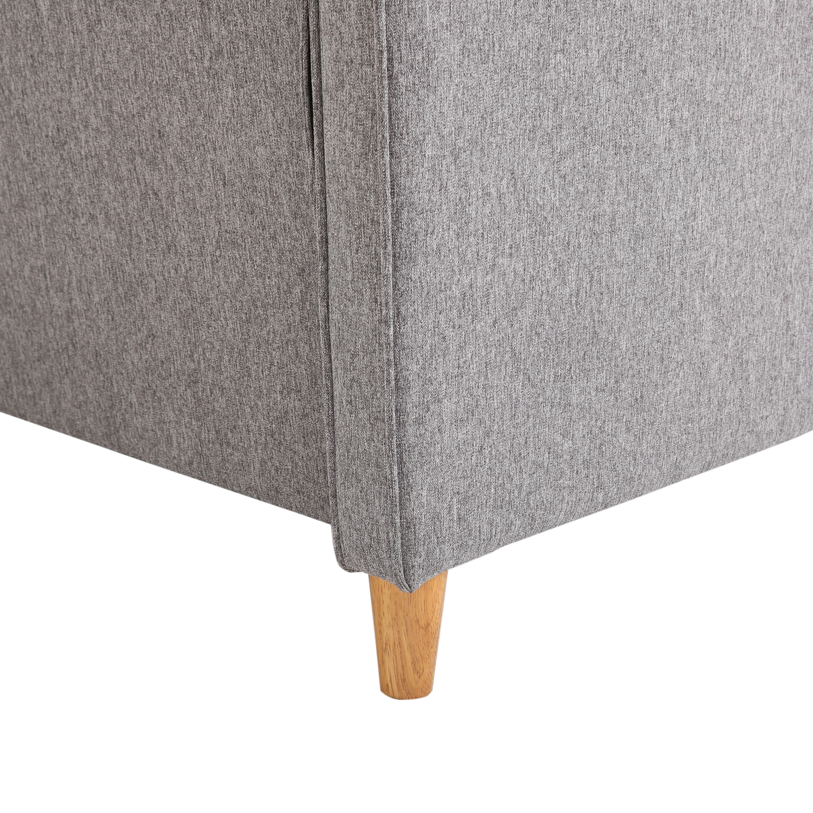 Nahaufnahme einer grauen Sofaecke mit Holzbeinen.