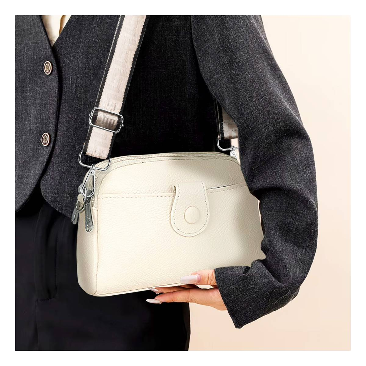 Frau hält eine weiße Leder-Crossbody-Tasche mit einem Riemen.