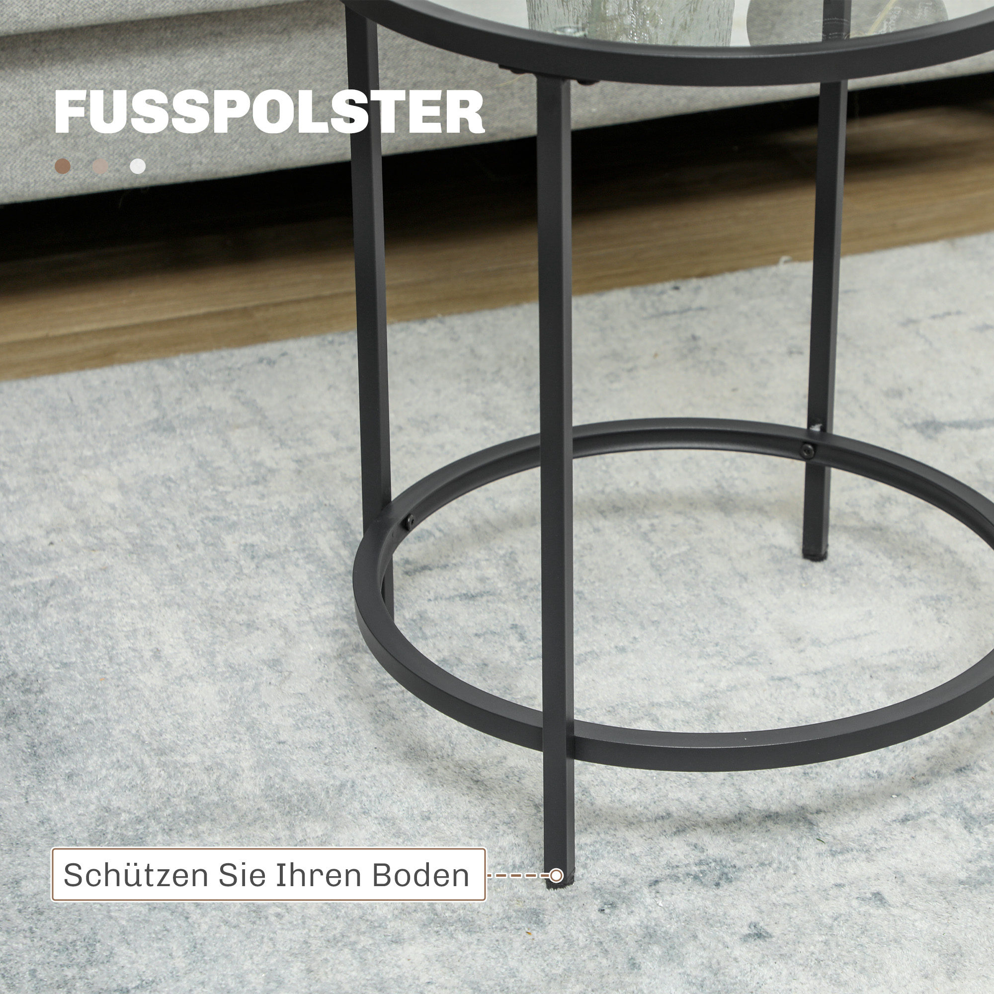 Ein schwarzer Metall-Beistelltisch mit Glasplatte, auf einem Teppich, in der Nähe eines Sofas.