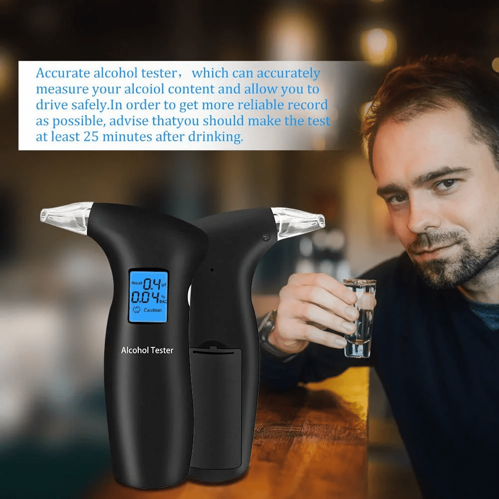 Mann hält ein Schnapsglas. Zwei Alkoholtester stehen vor ihm. Das Display zeigt einen Wert.