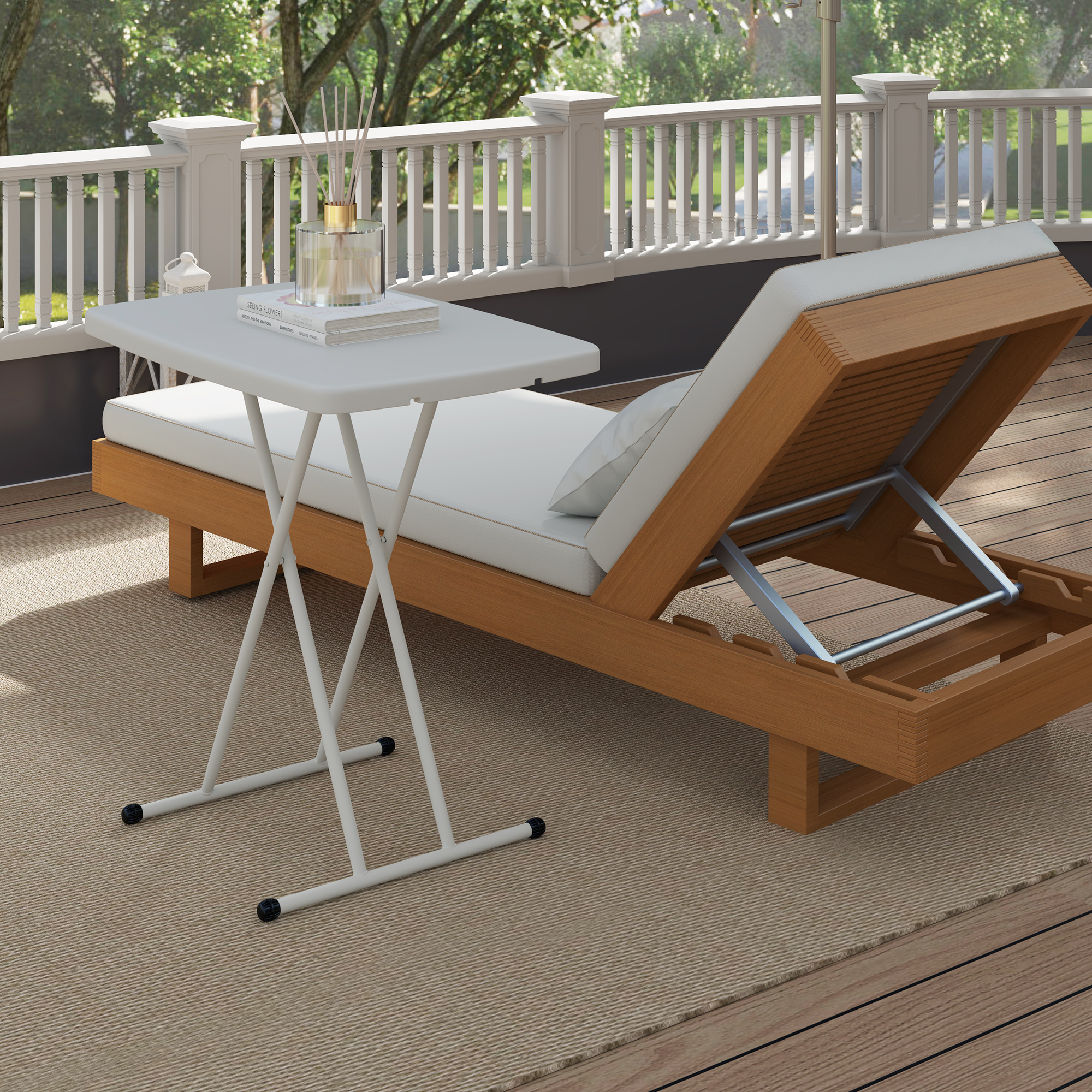 Tavolo pieghevole bianco e chaise longue su un terrazzo con vista giardino.