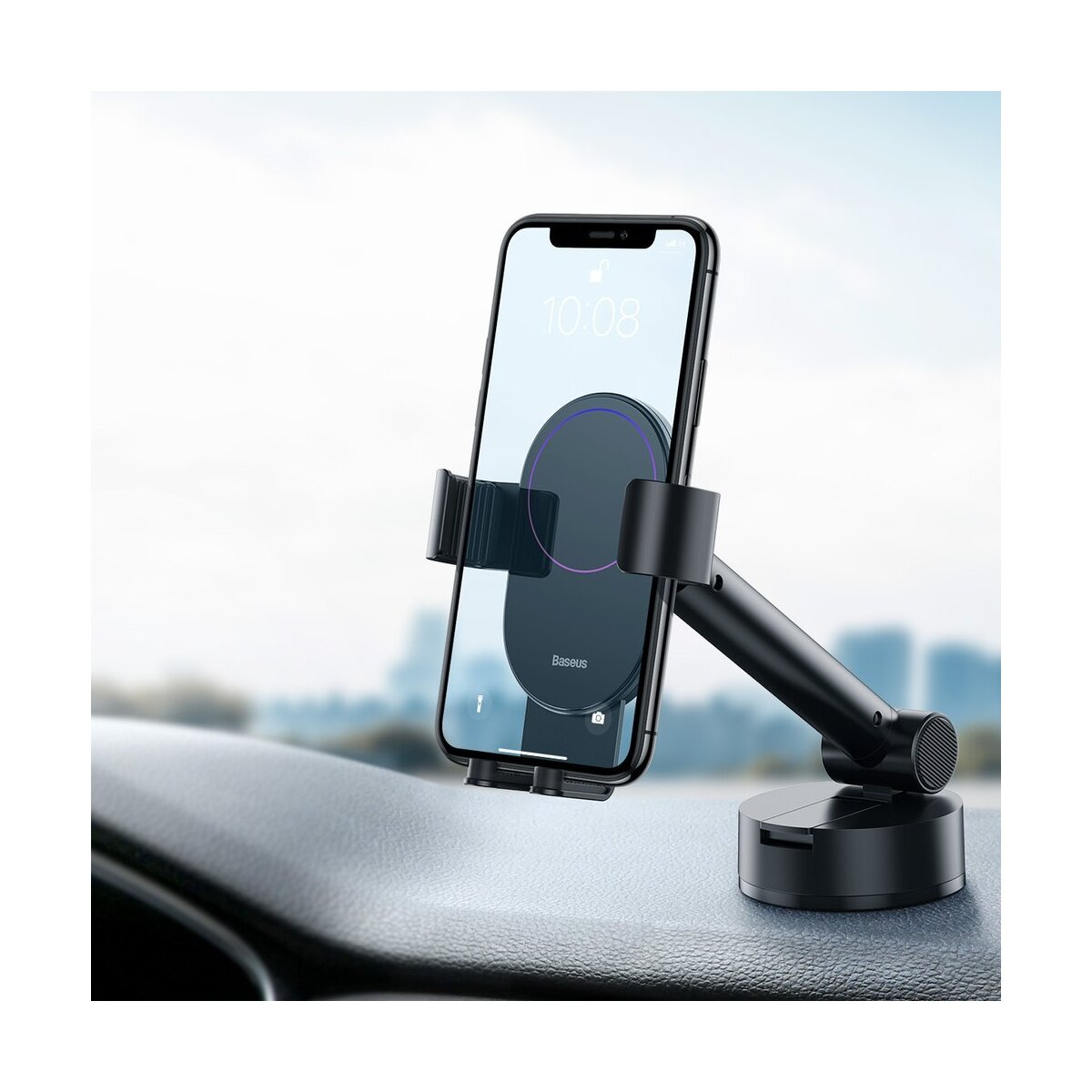 Czarny uchwyt na telefon w samochodzie. Telefon jest zamontowany na uchwycie. Tło to rozmyty krajobraz miejski.