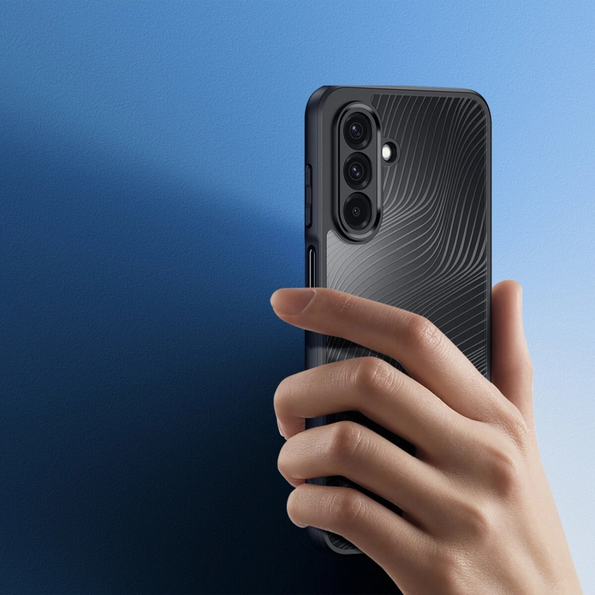 Hand hält ein schwarzes Telefon mit Hülle. Die Hülle hat wellenförmige Linien und einen blauen Farbverlauf.