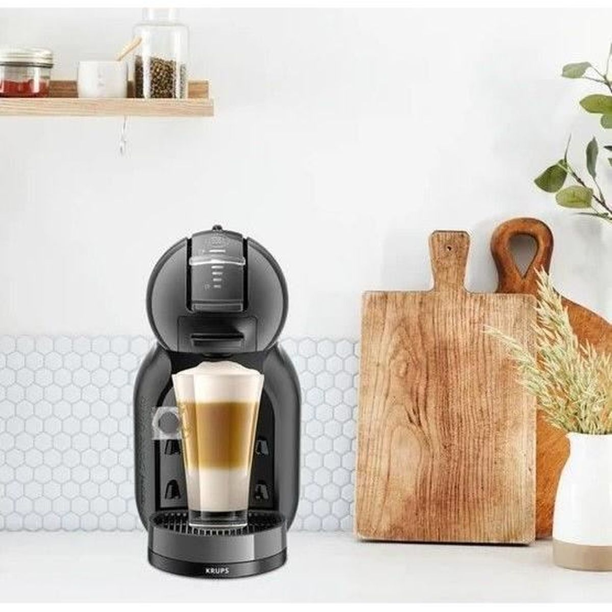 Czarny ekspres do kawy z latte w szklance, drewniane deski po prawej.