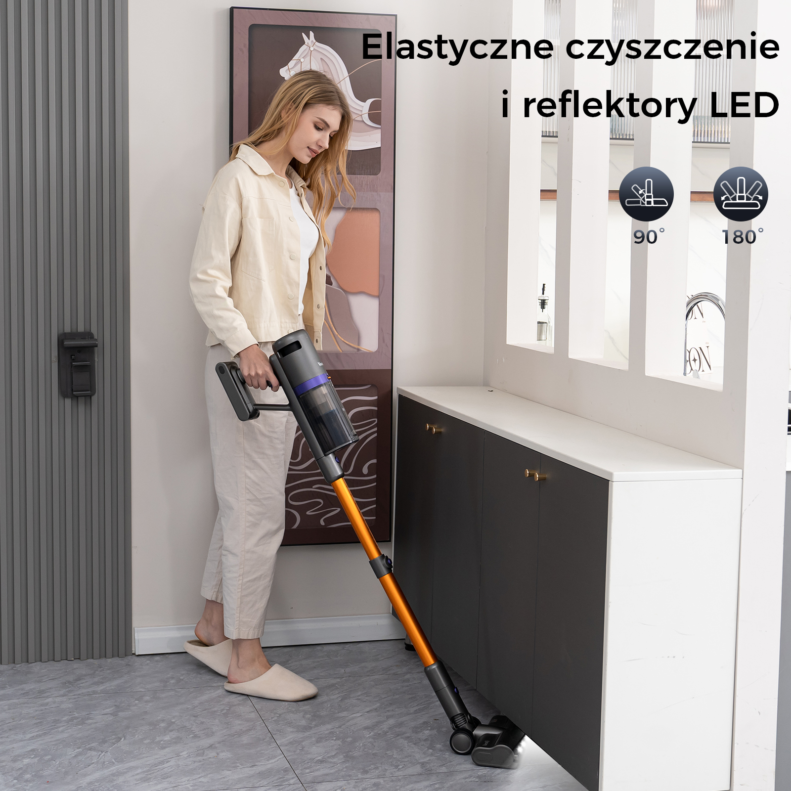 Kobieta używa odkurzacza w korytarzu. Odkurzacz ma pomarańczową rurę i czyści podłogę.