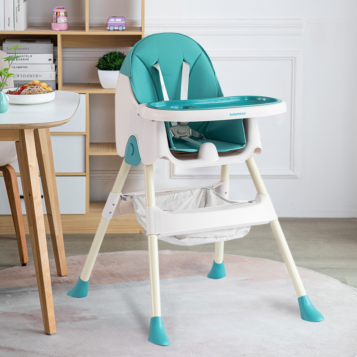 Ein grüner und weißer Babyhochstuhl mit Tablett und Aufbewahrungskorb.