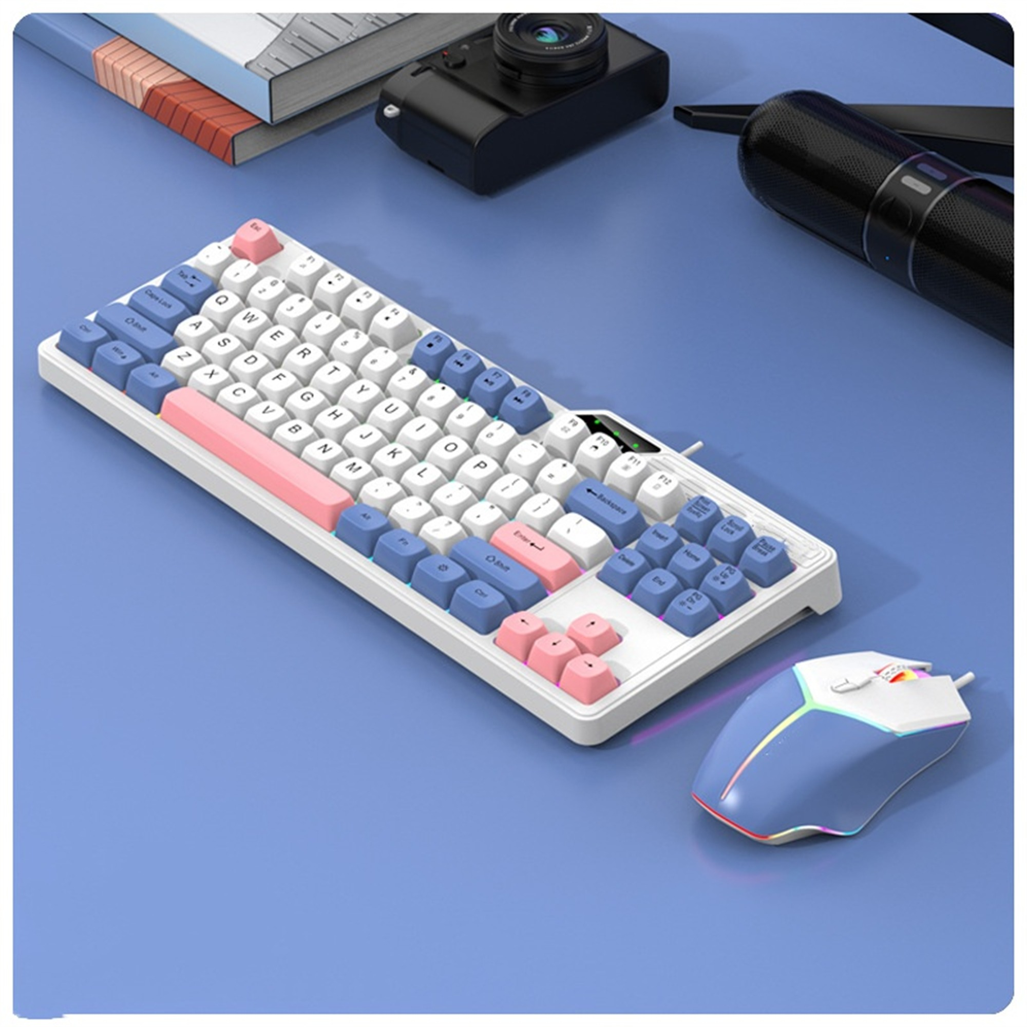 Tastatur und Maus auf blauem Schreibtisch. Weiße Tastatur mit rosa und blauen Tasten. Maus ist blau.