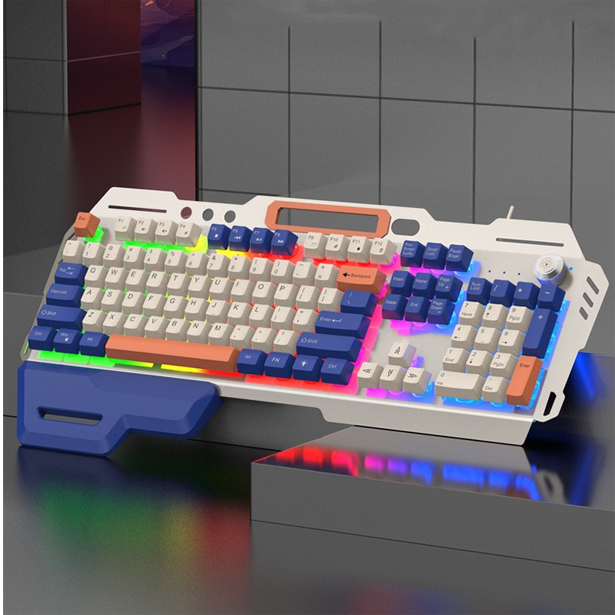 Gaming-Tastatur mit mehreren Farben, weißem und blauem Rahmen, auf grauer Oberfläche.