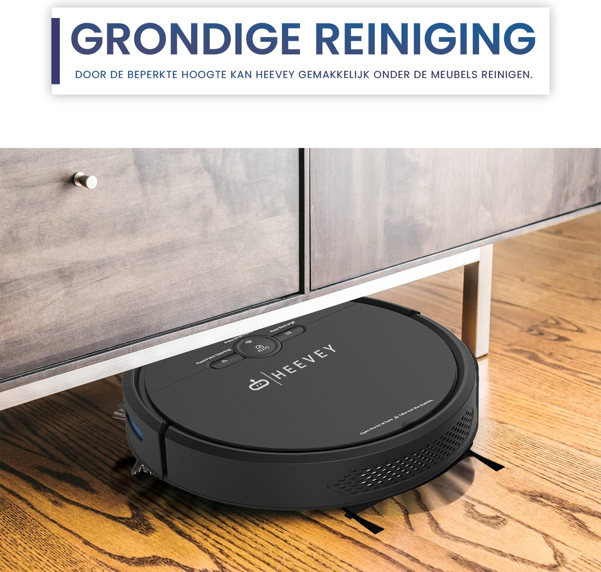 Aspirateur robot noir nettoyant sous une armoire en bois sur un parquet.
