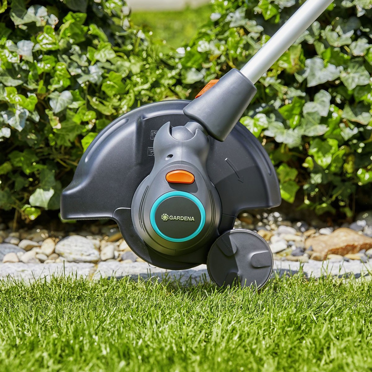 Ein Gardena Rasenkantenschneider, der Gras schneidet, mit grünem und grauem Design.