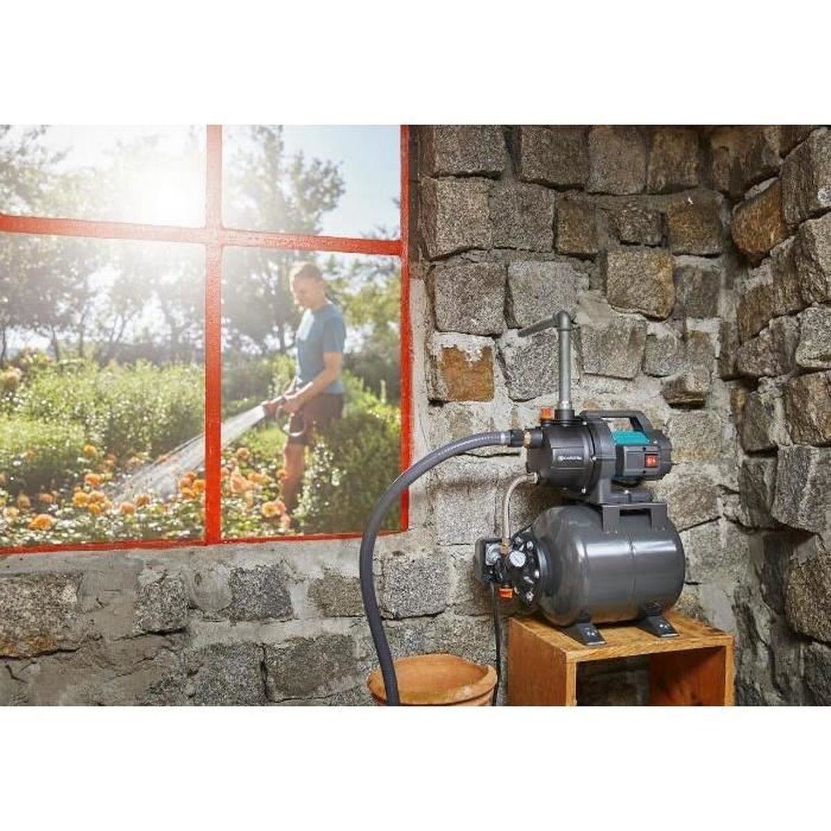 Mann, der Pflanzen außerhalb eines Fensters gießt. Wasserpumpe im Raum aufgebaut.