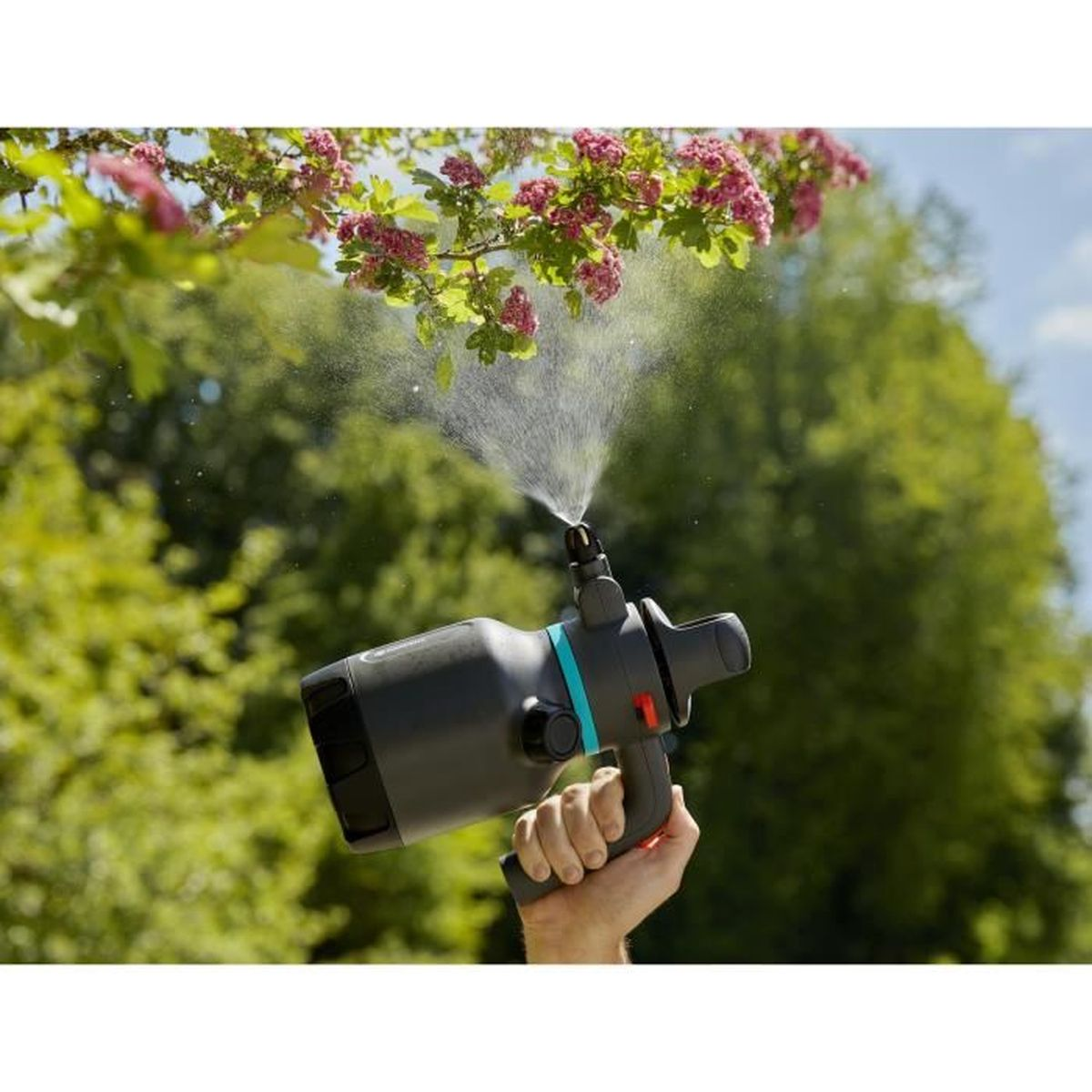 Eine Person hält einen schwarz-grauen Wassersprüher, aus dem Wasser gesprüht wird.